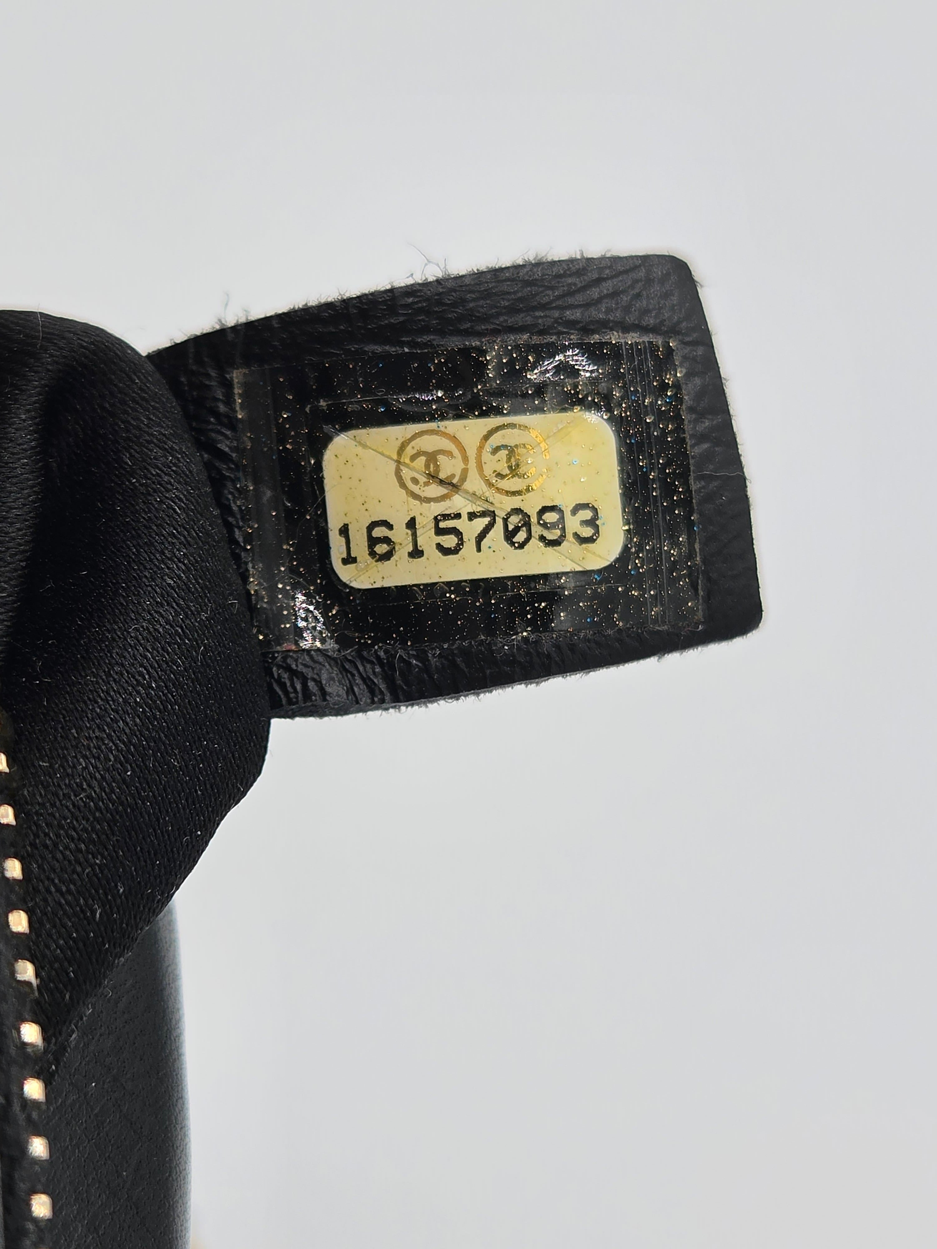 Close-up of a black shoe tag with a gold label on a light gray background