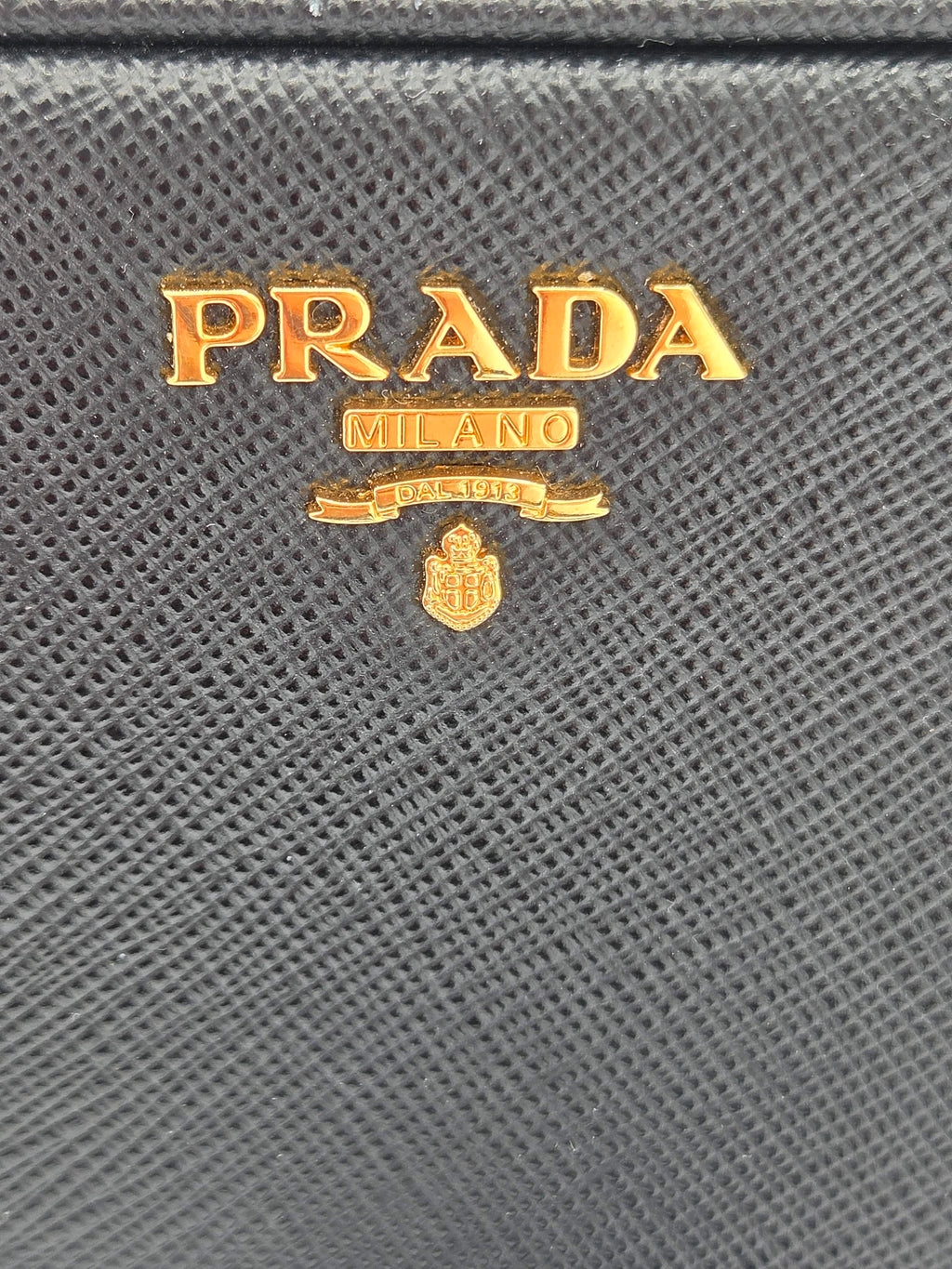 Close-up of Prada logo on a textured gray surface
