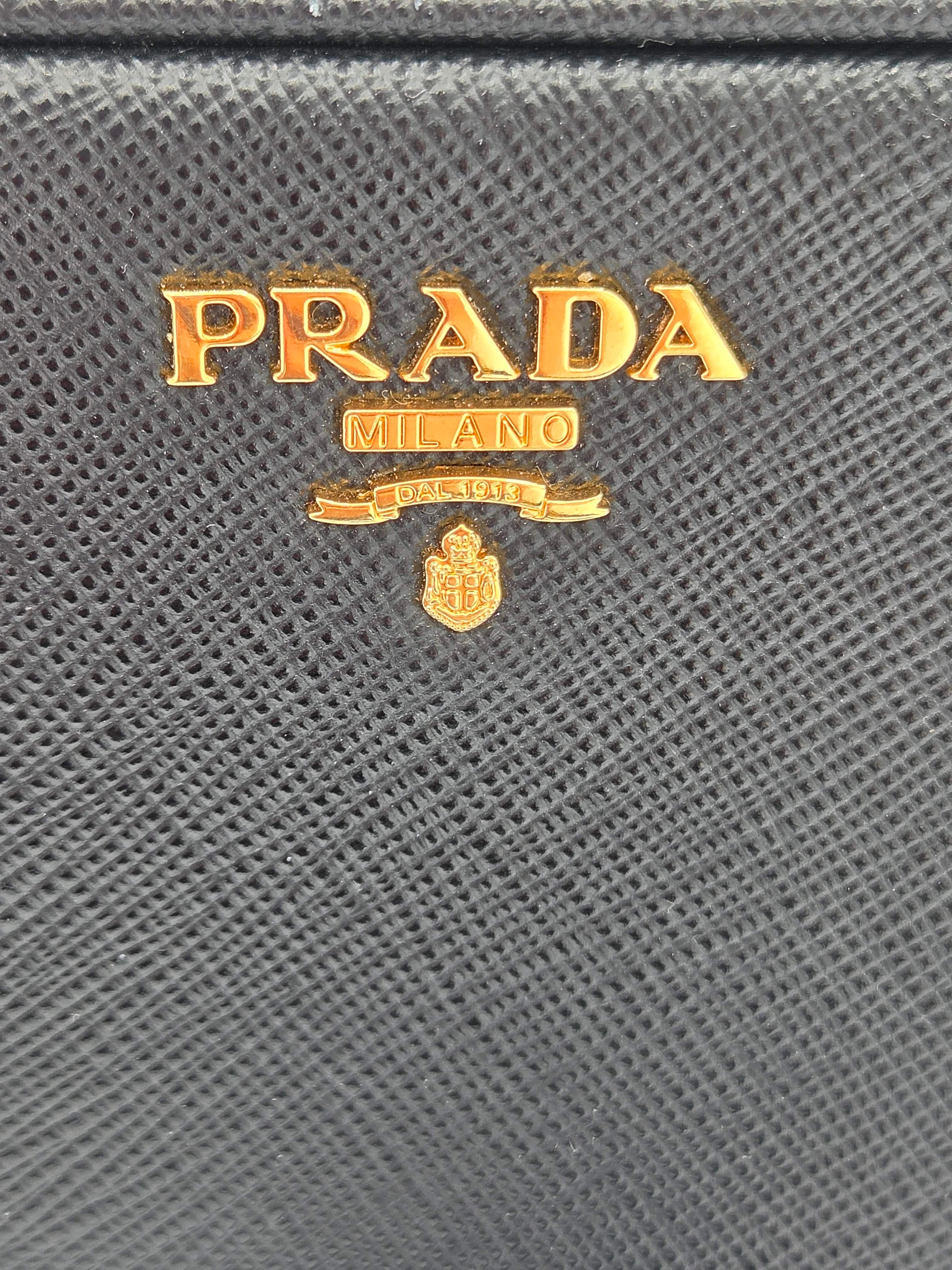 Close-up of Prada logo on a textured gray surface