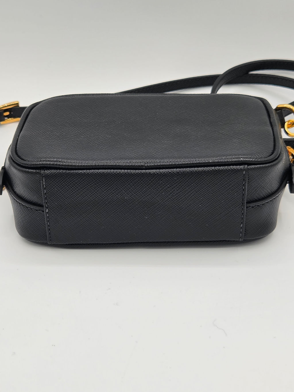 Black leather crossbody bag on a light gray background