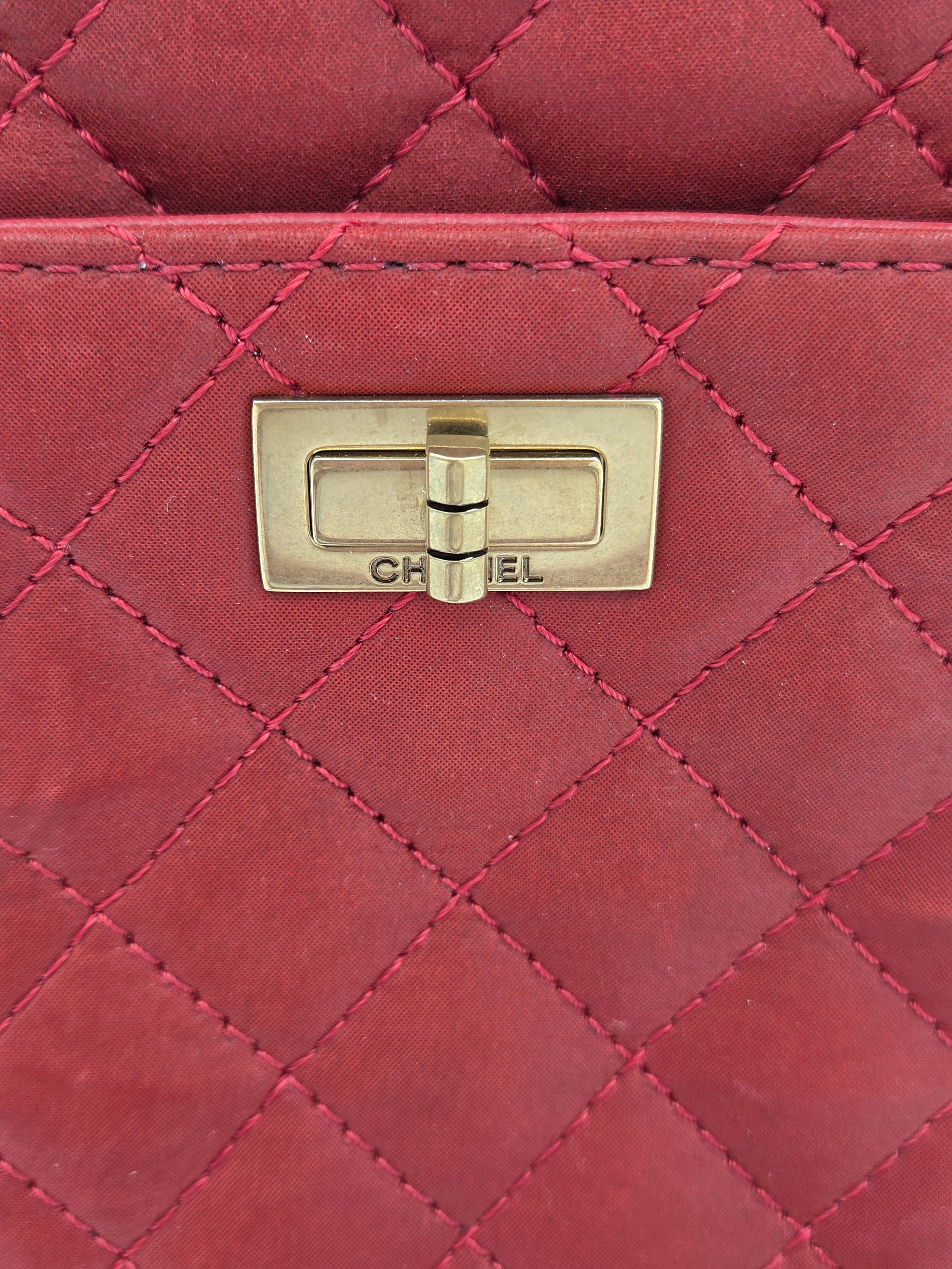 Close-up of a red quilted handbag with a gold clasp.