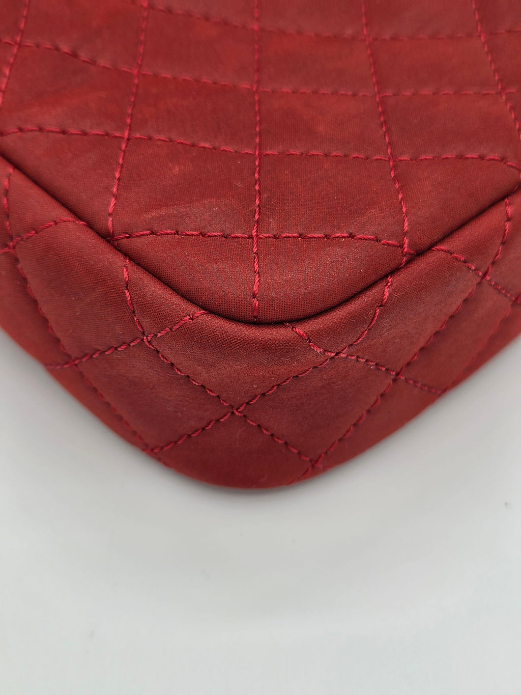 Close-up of a red quilted leather patch on a light gray background