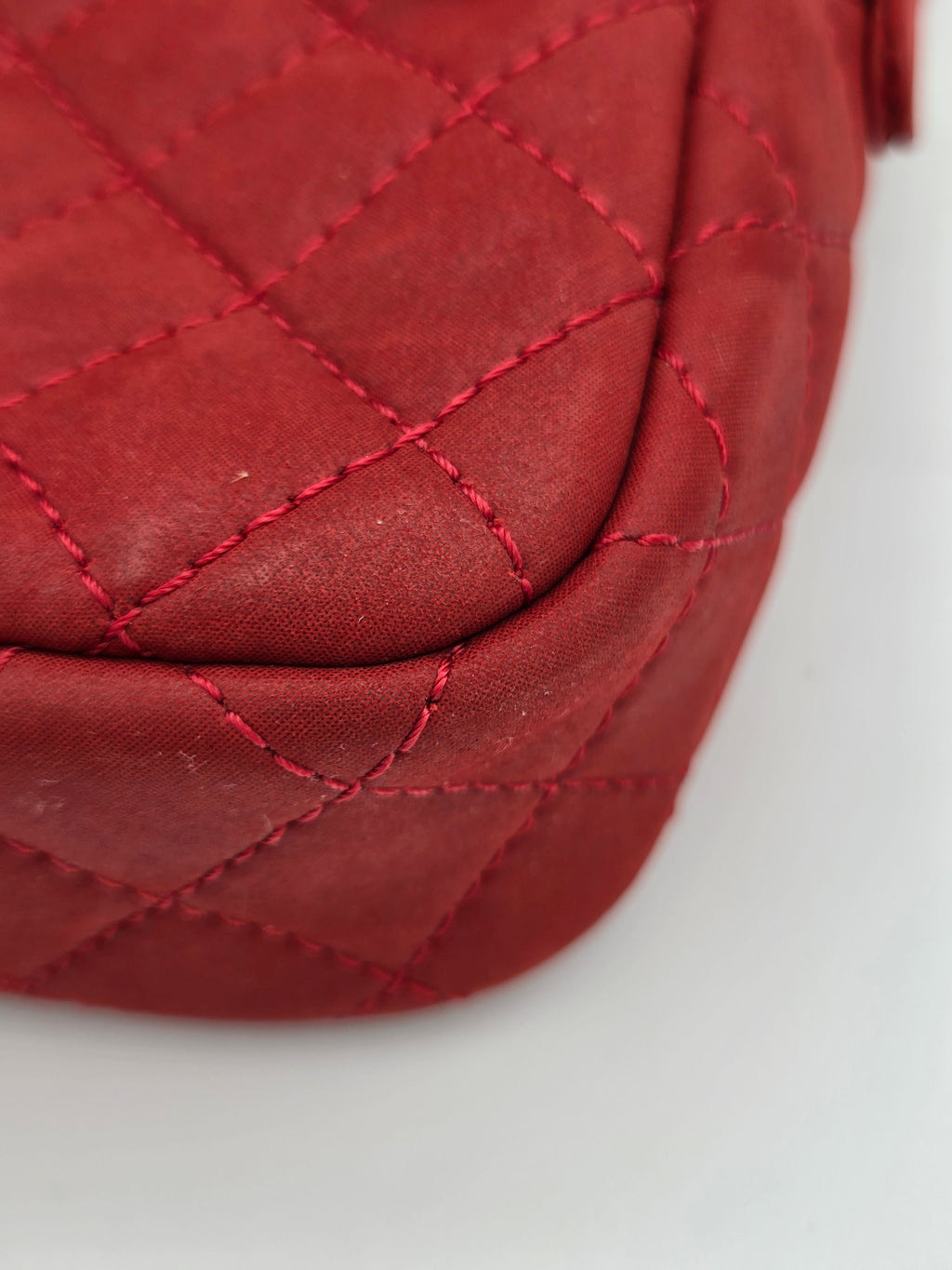 Close-up of a red quilted fabric surface with a white background