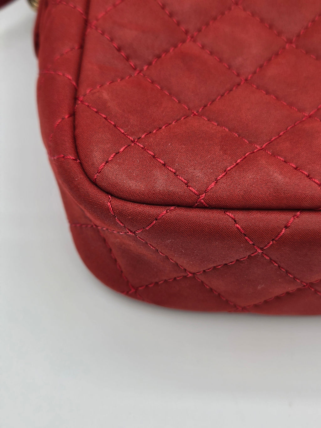 Close-up of a red quilted leather bag on a white background