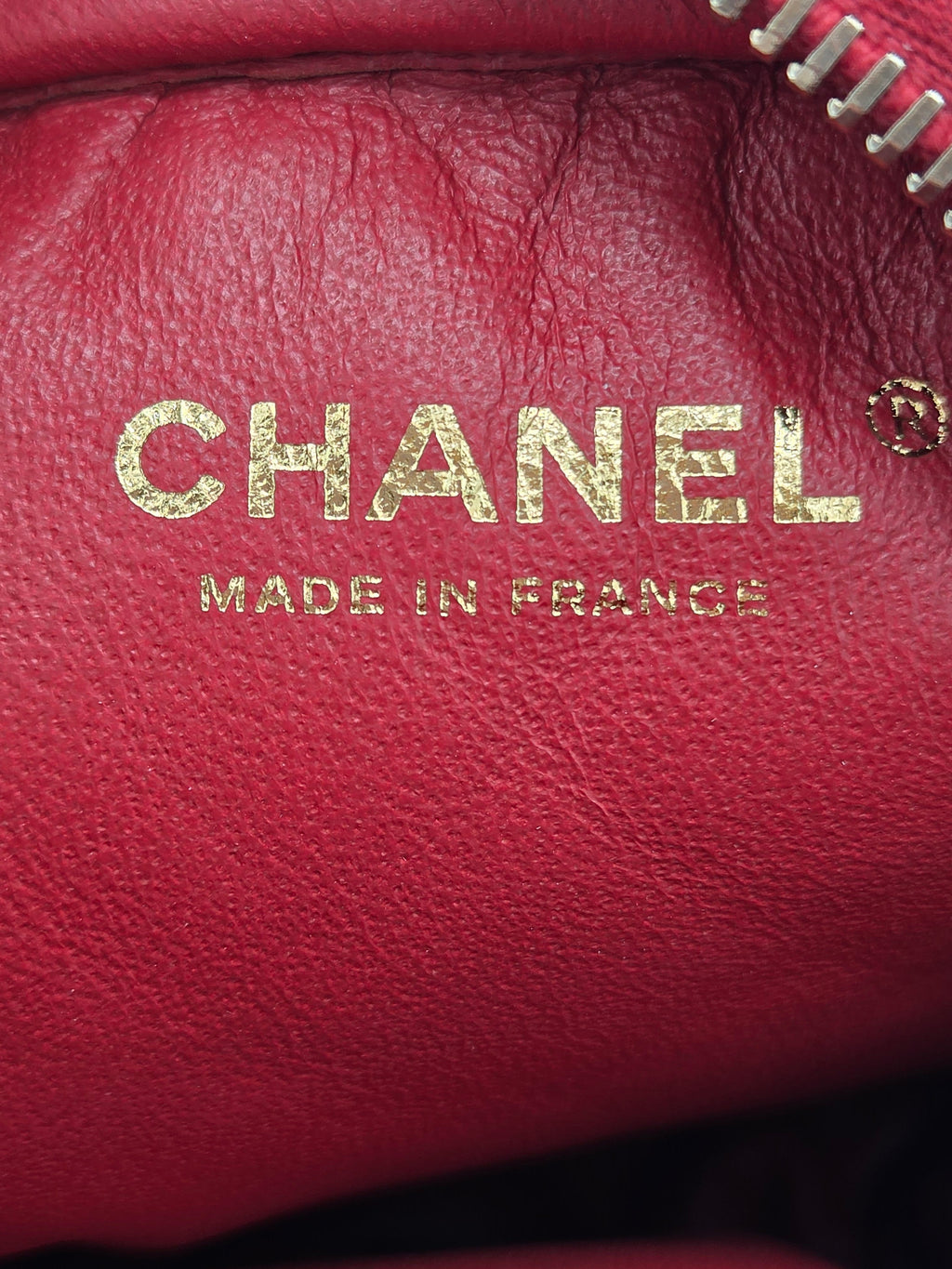 Close-up of a Chanel logo on a red leather surface