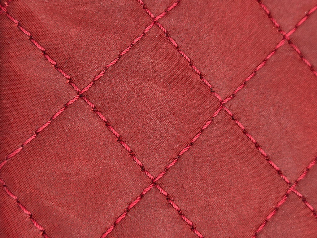 Close-up of red quilted fabric with diamond pattern