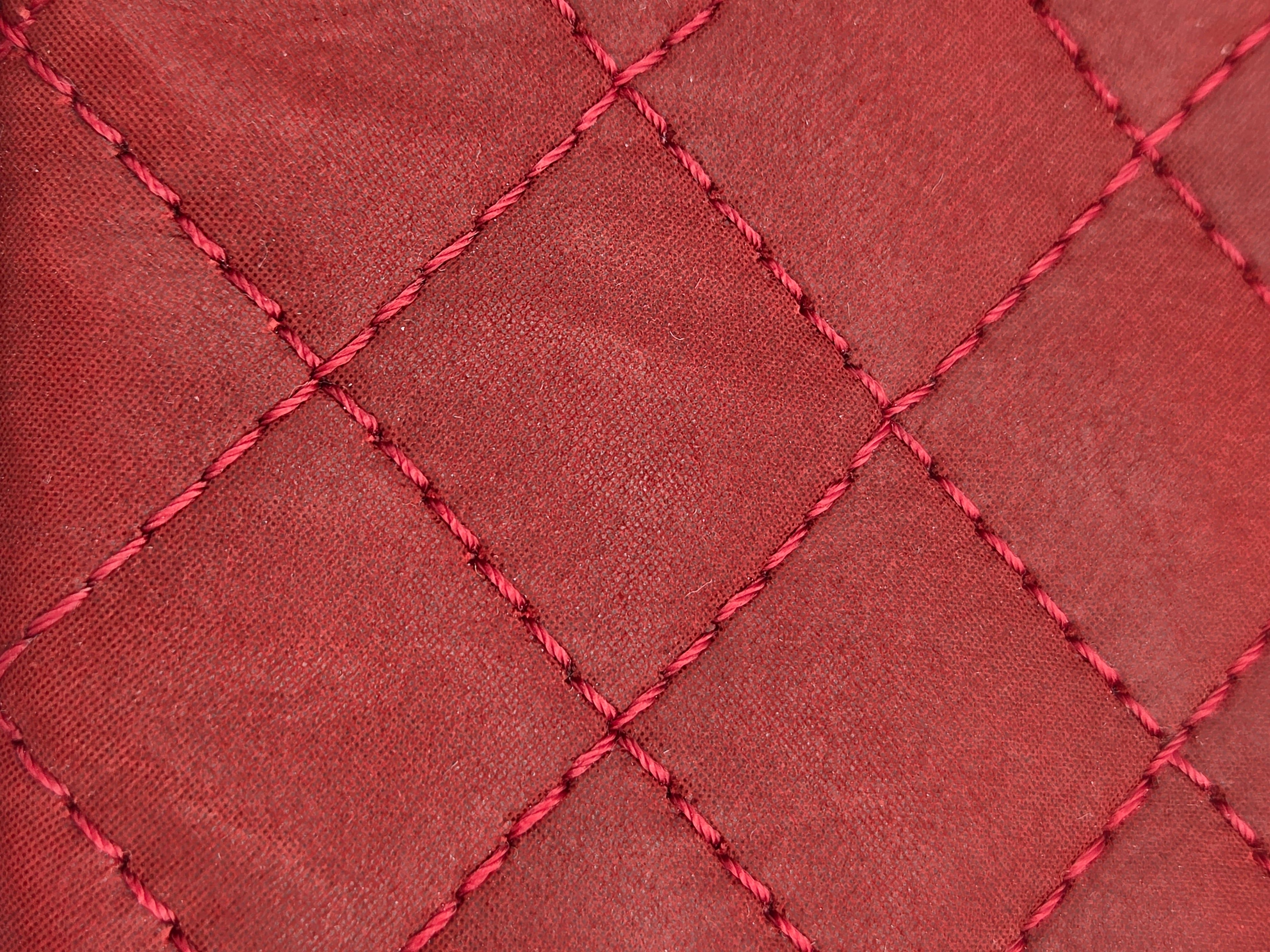 Close-up of red quilted fabric with diamond pattern