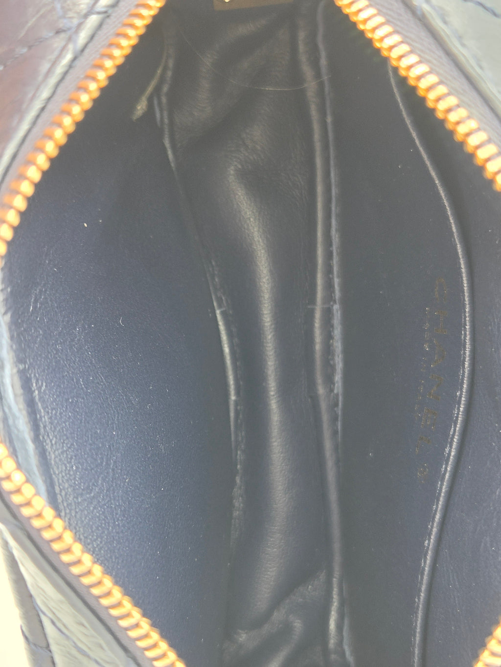 Open black leather handbag with gold zipper