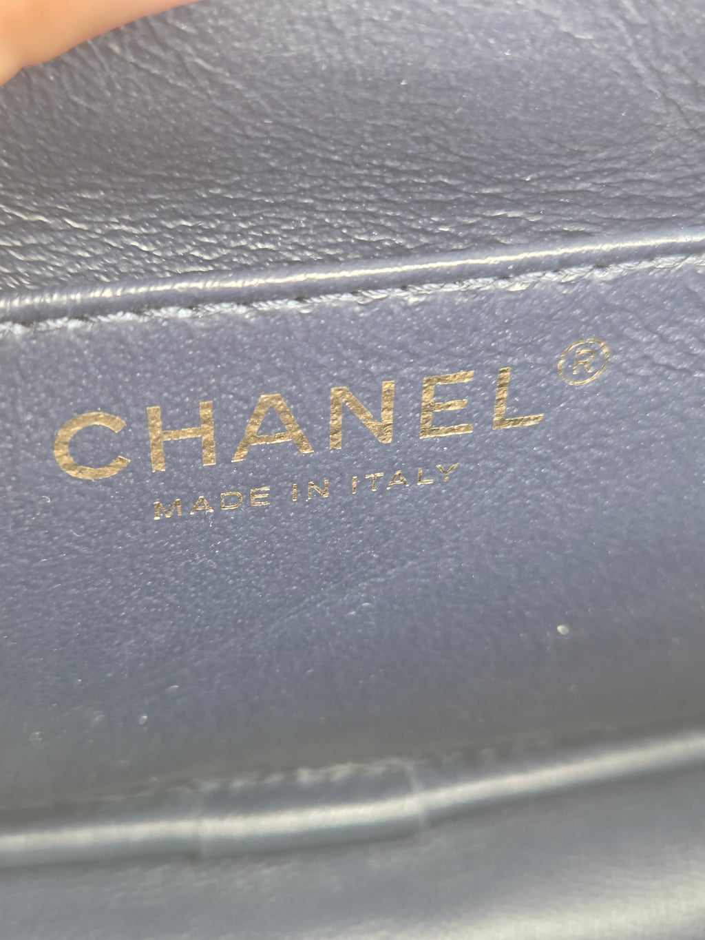 Close-up of a Chanel logo on a dark surface