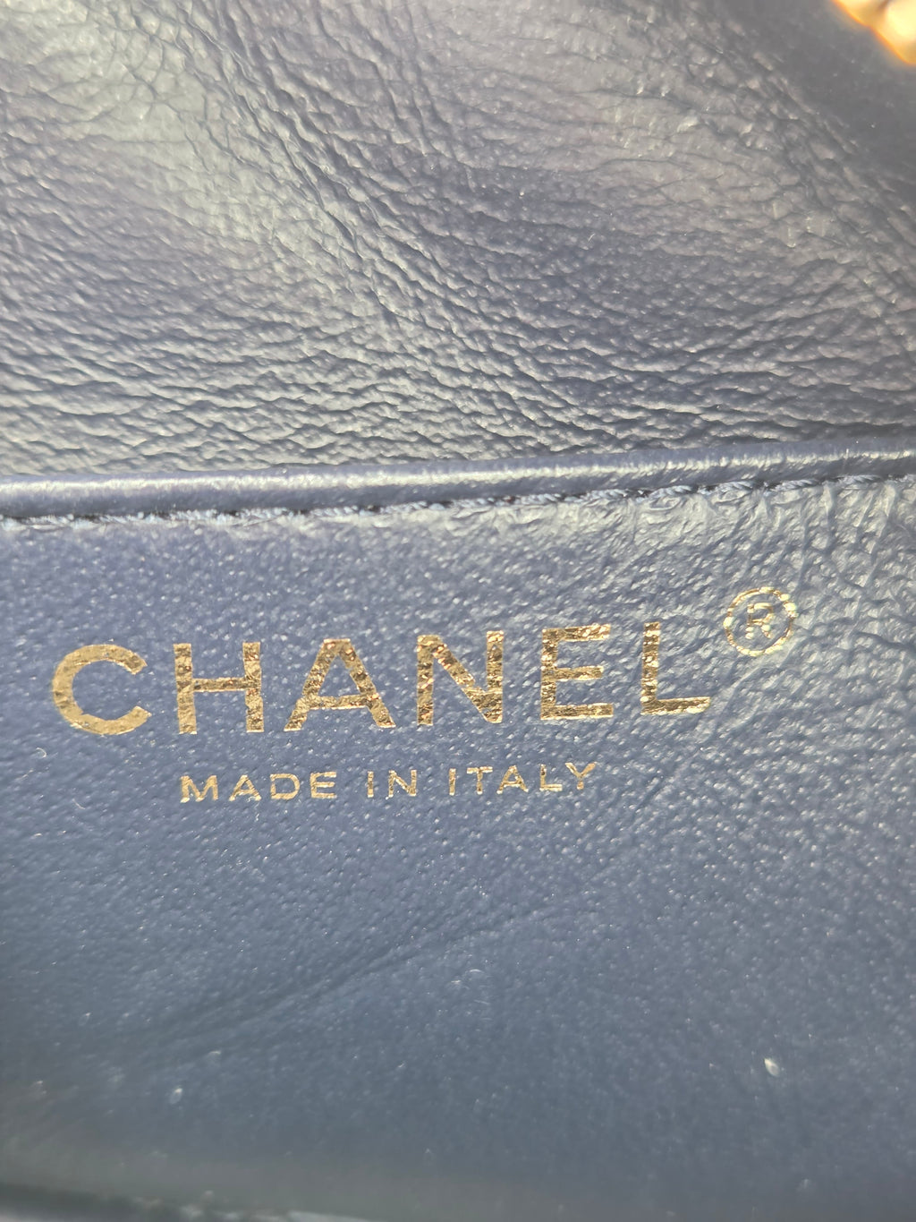 Close-up of Chanel logo on a textured surface