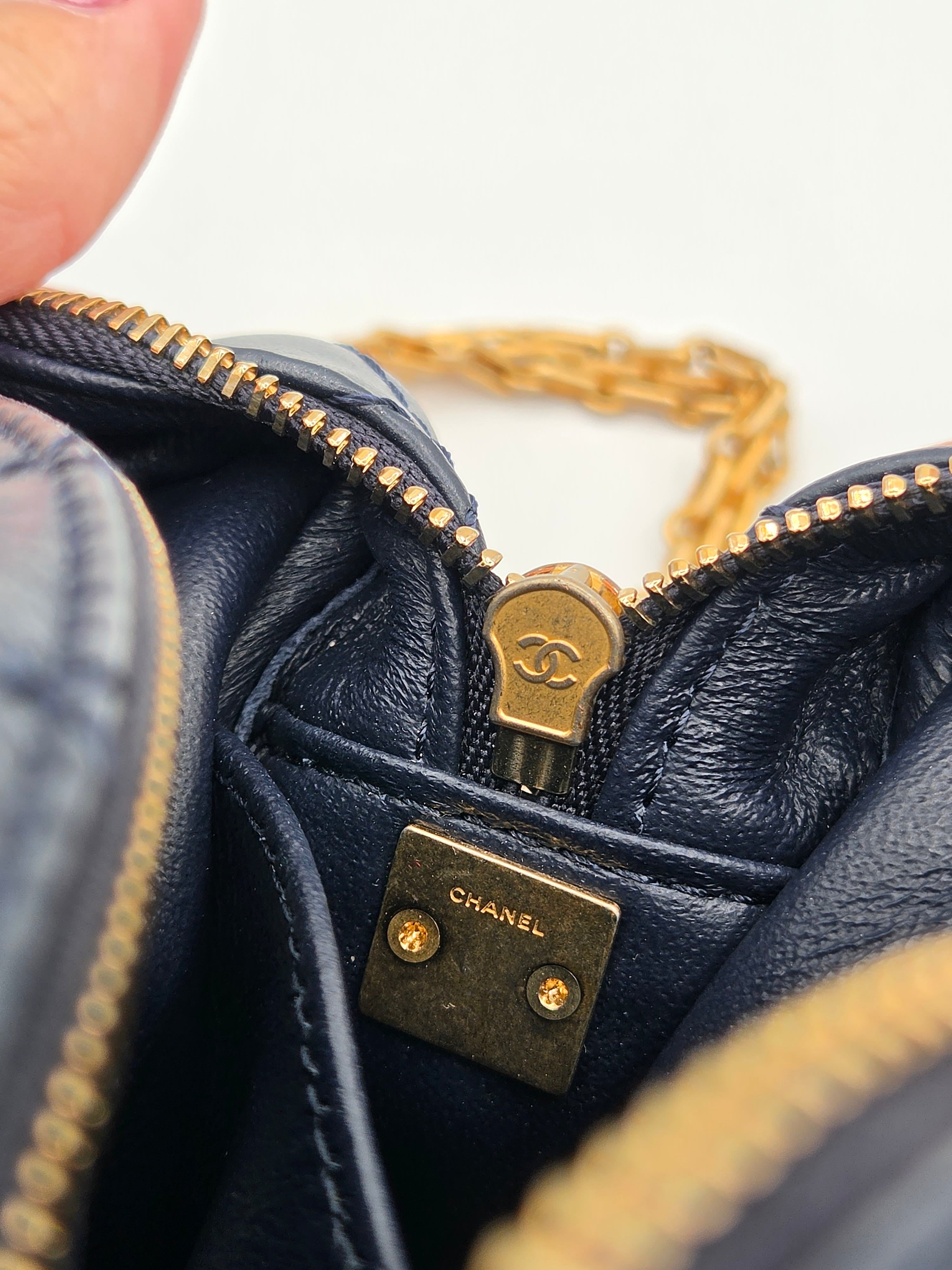Close-up of a Chanel handbag with gold zipper and hardware.