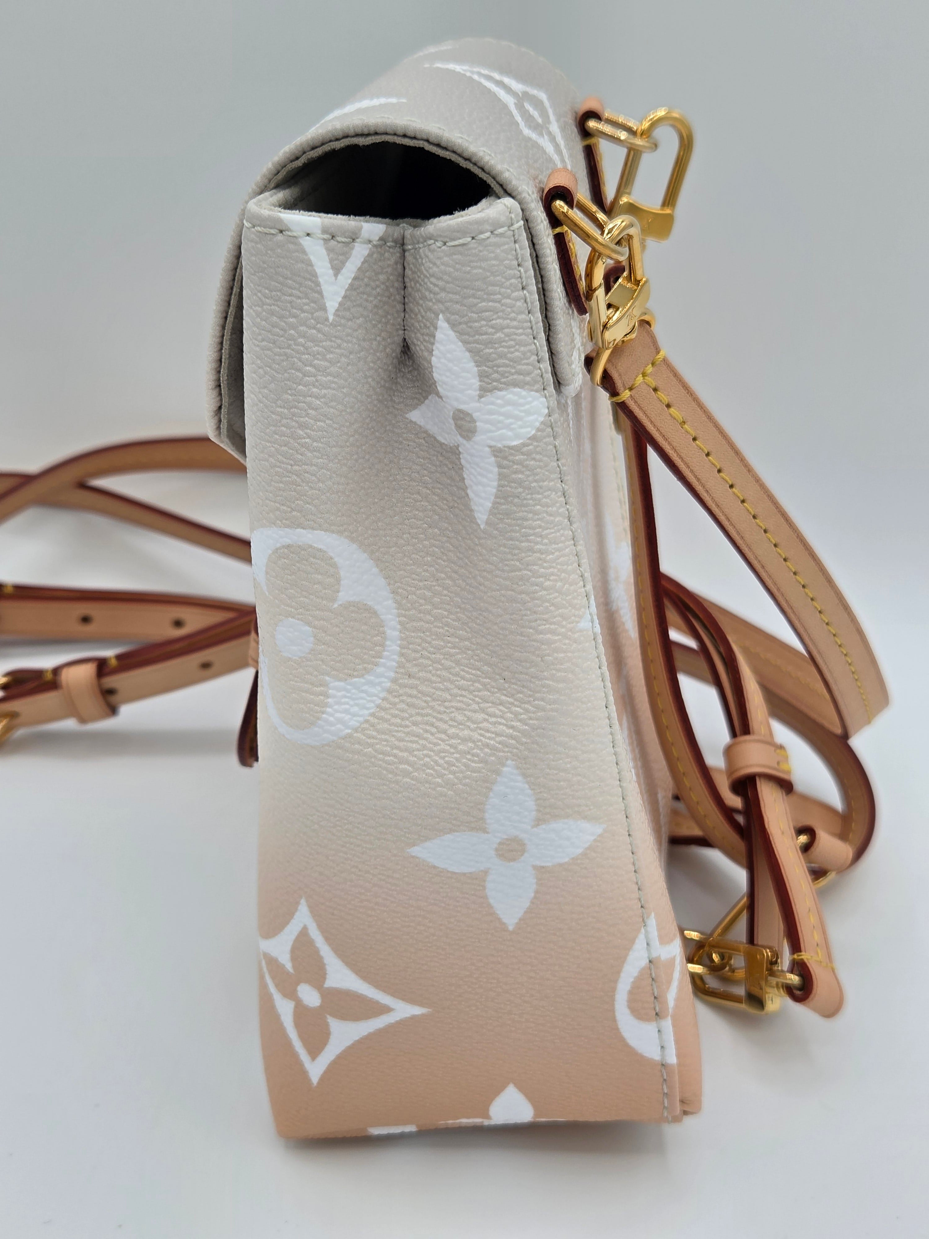 Designer handbag with monogram pattern on a light gray background