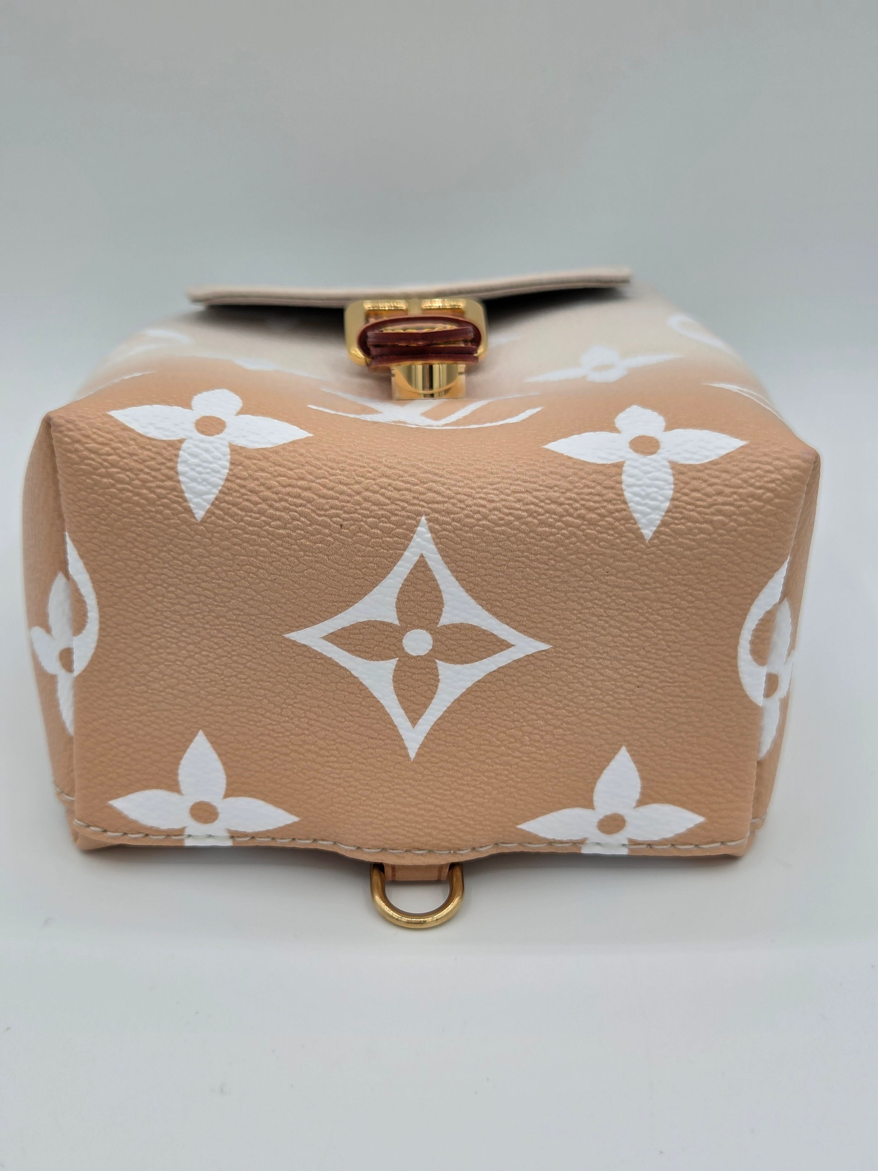 Beige wallet with white floral pattern on a light gray background