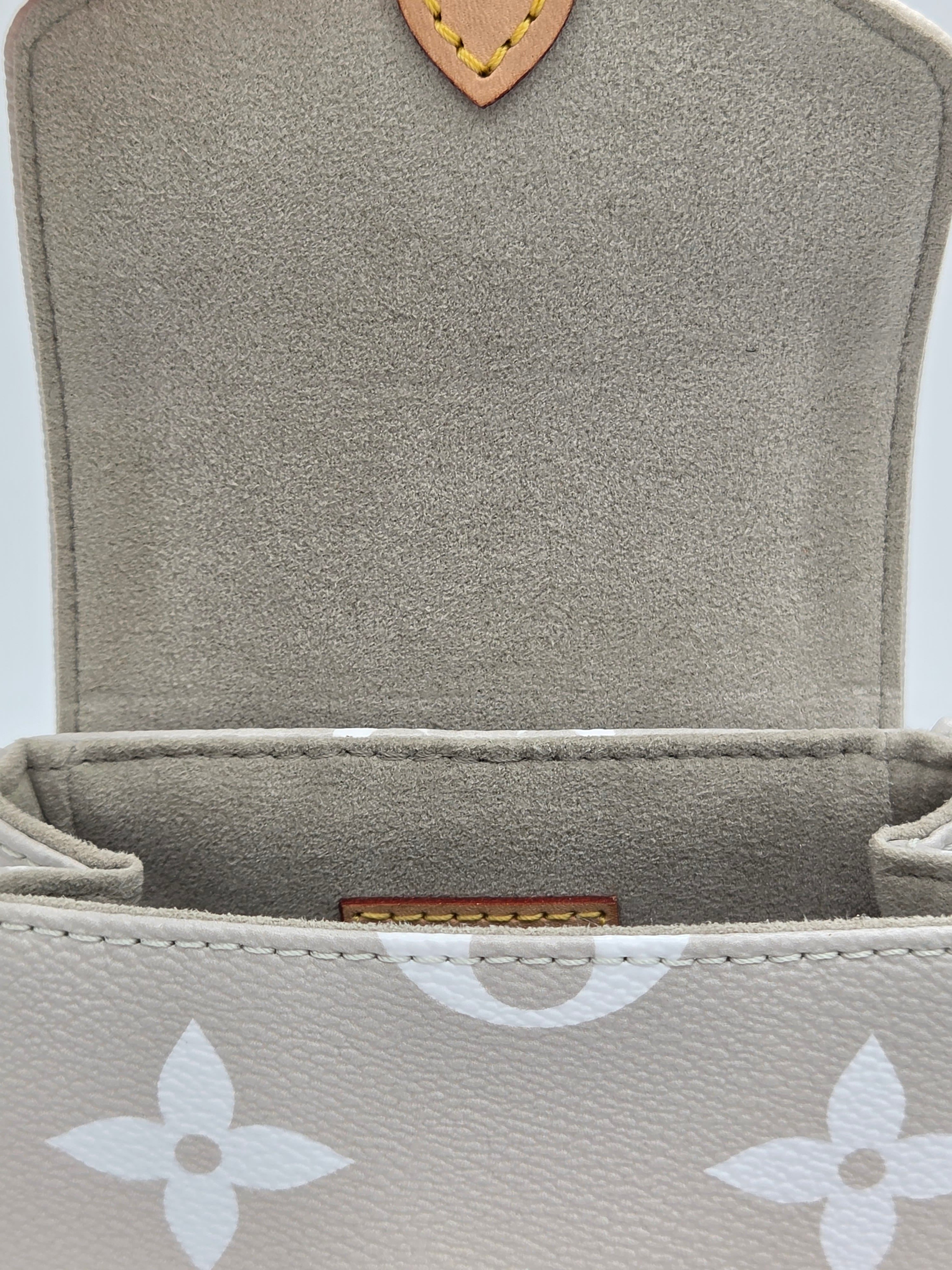 Close-up of a textured gray pouch with a brand logo on a white background
