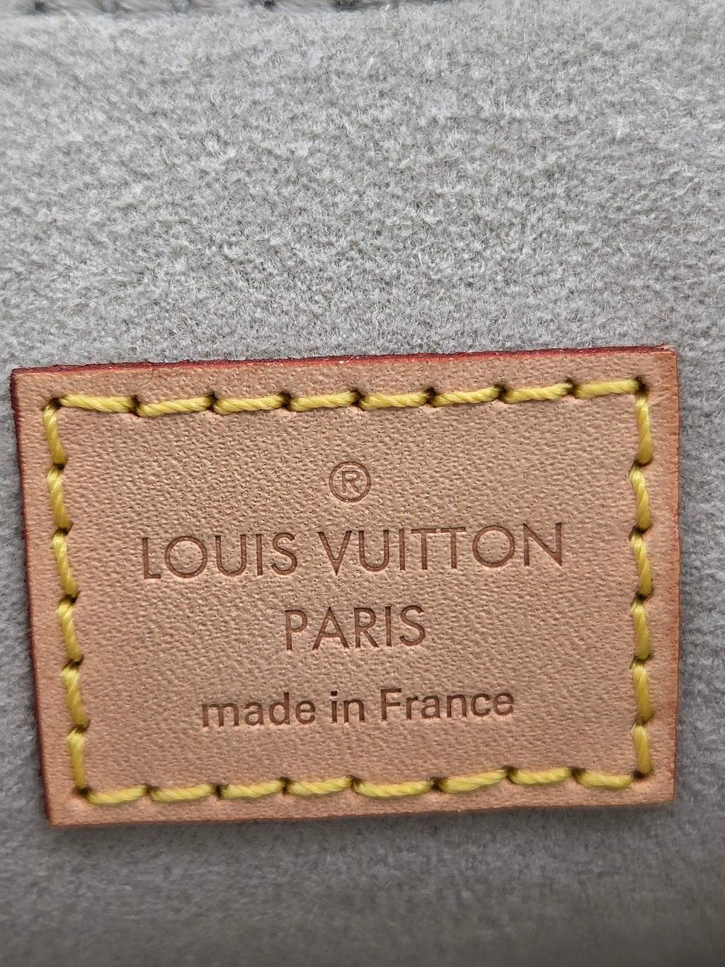 Louis Vuitton label on a textured gray background