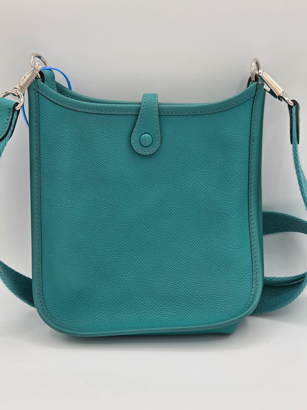 Teal handbag with a strap on a light gray background