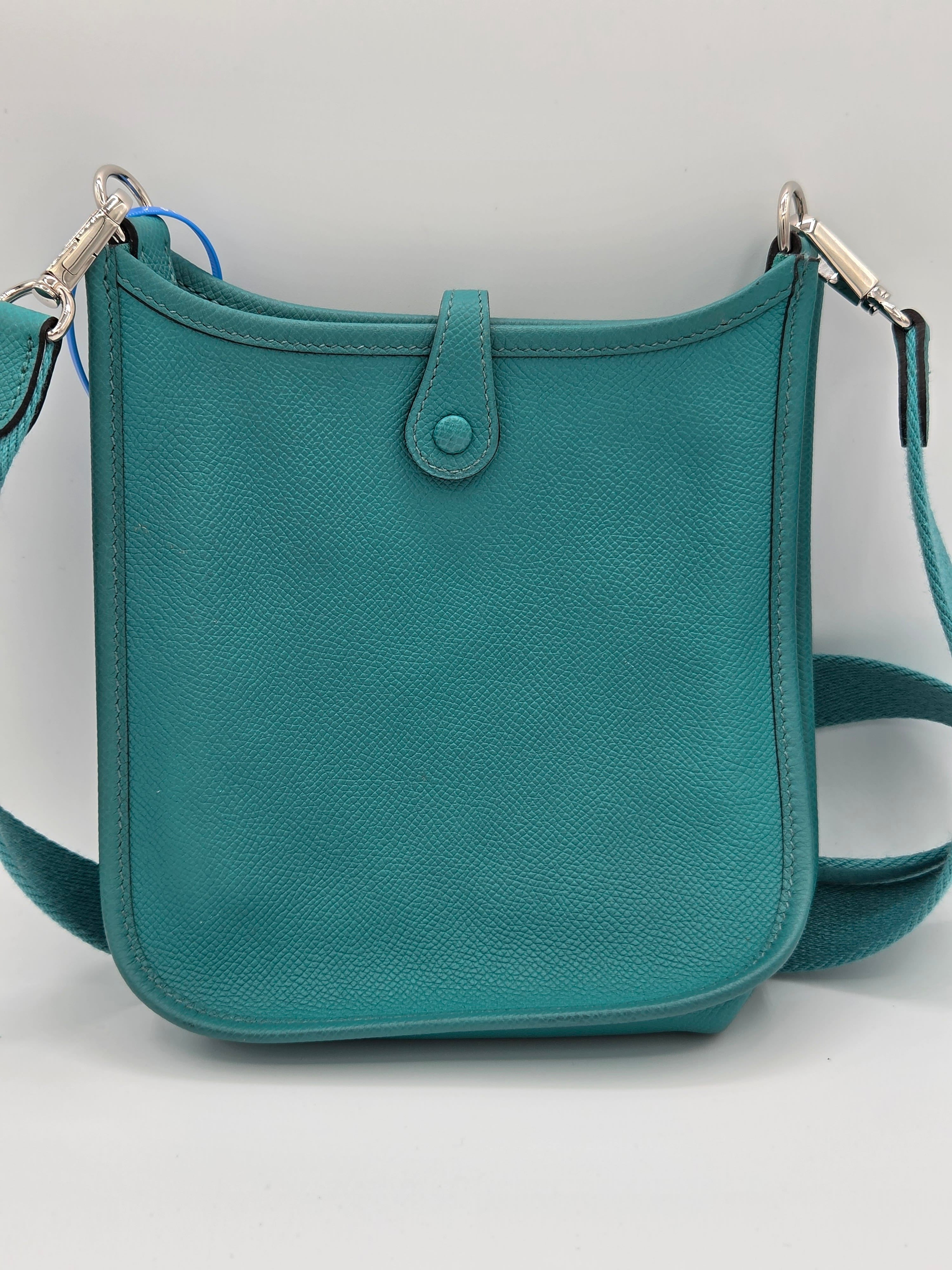 Teal handbag with a strap on a light gray background
