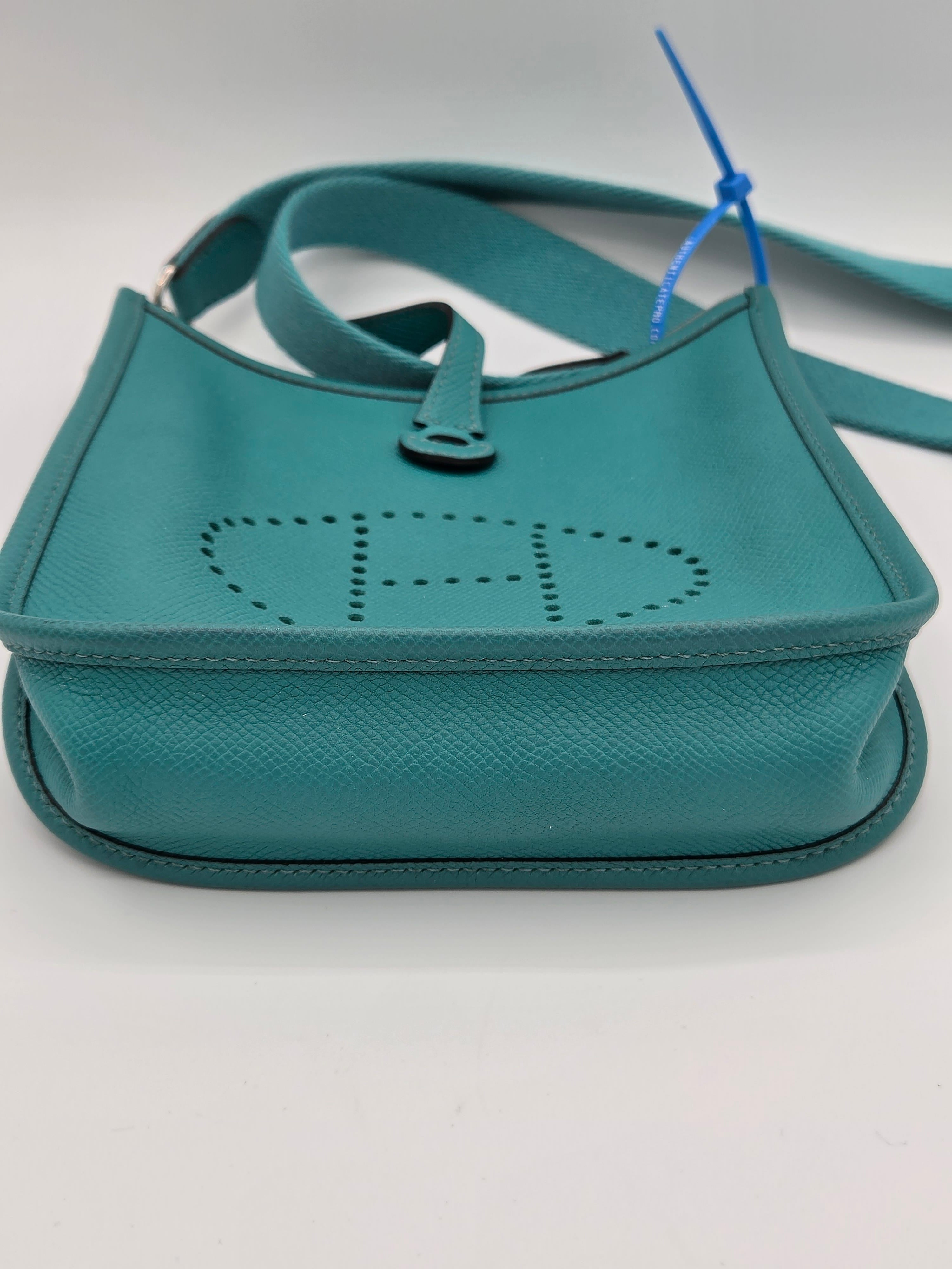 Teal handbag with a visible brand logo on a light gray background