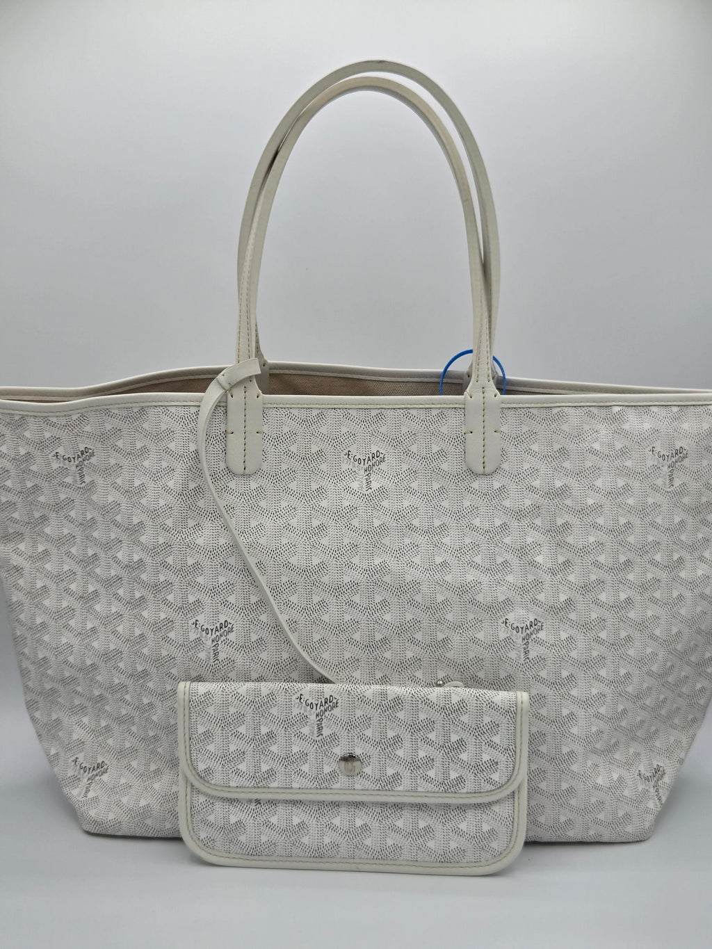 Gray patterned handbag with a smaller pouch on a light gray background