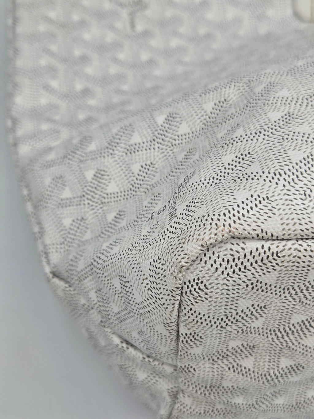Close-up of a textured gray fabric with a subtle pattern on a light gray background
