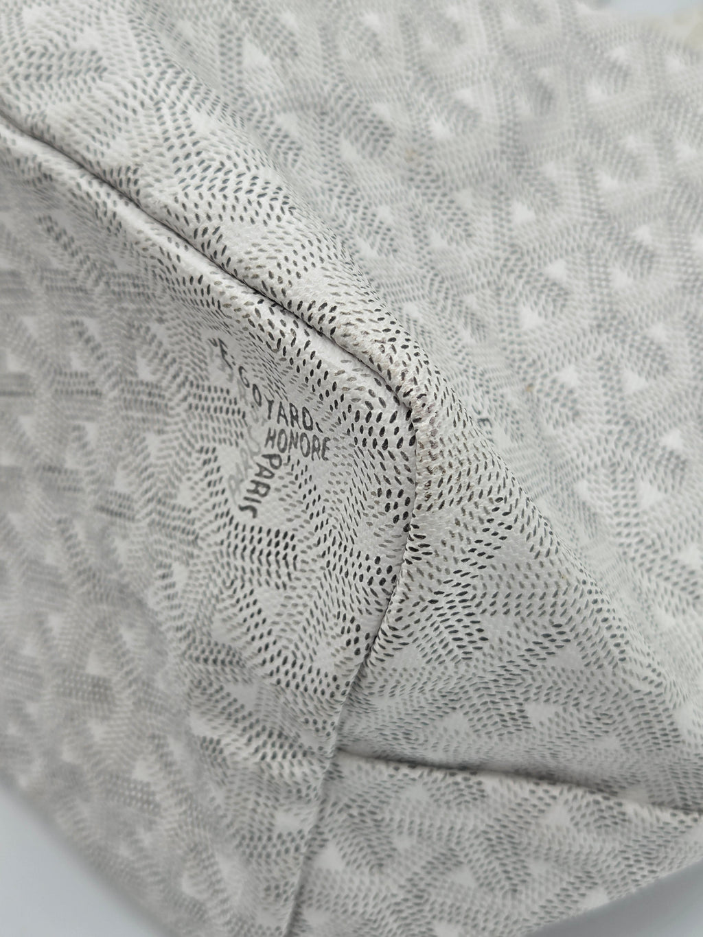 Close-up of a textured fabric with a brand logo on a light gray background