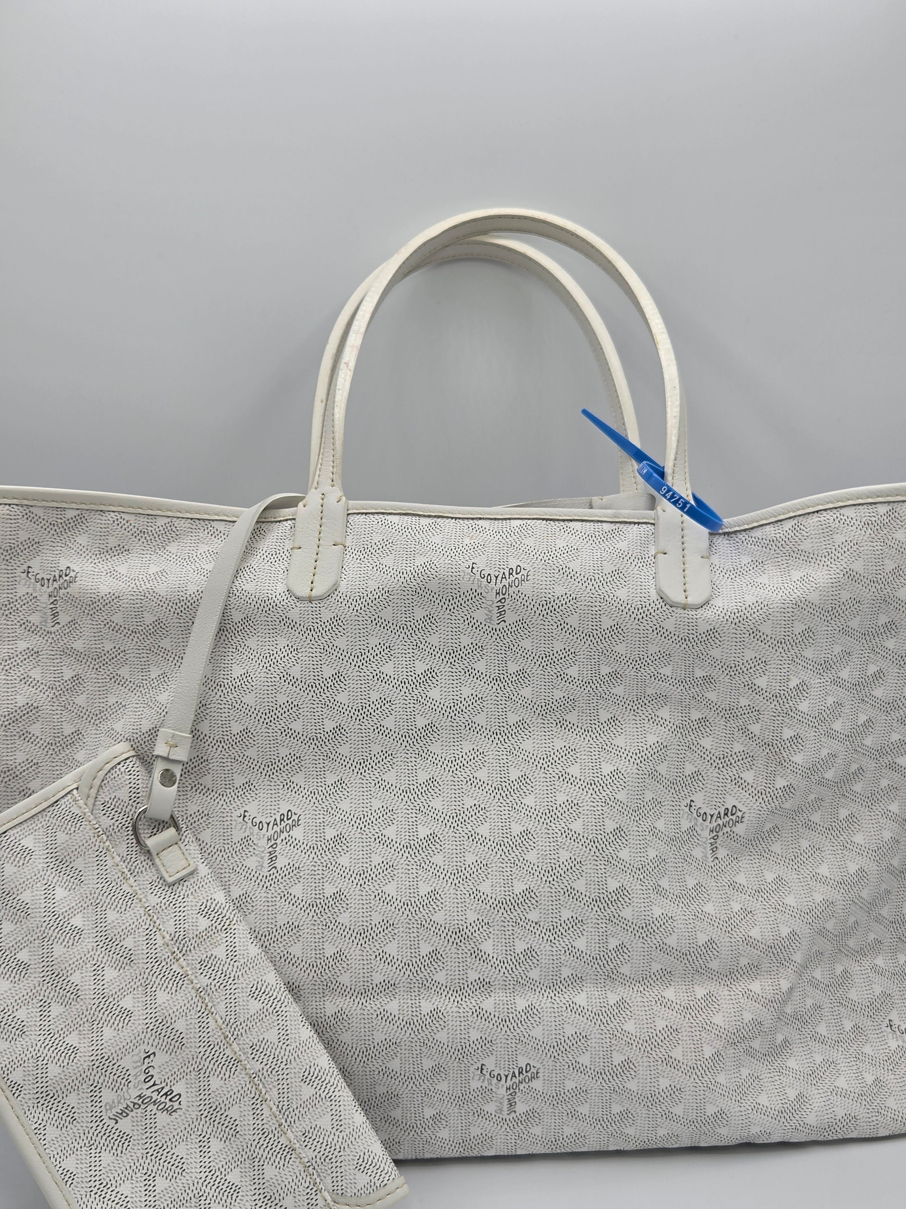 Gray patterned bag with a blue tag on a light gray background