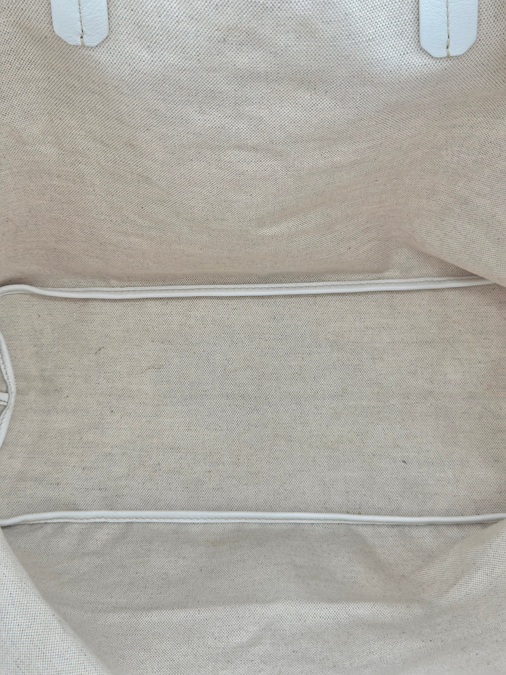 Close-up of a beige fabric bag with visible stitching details.