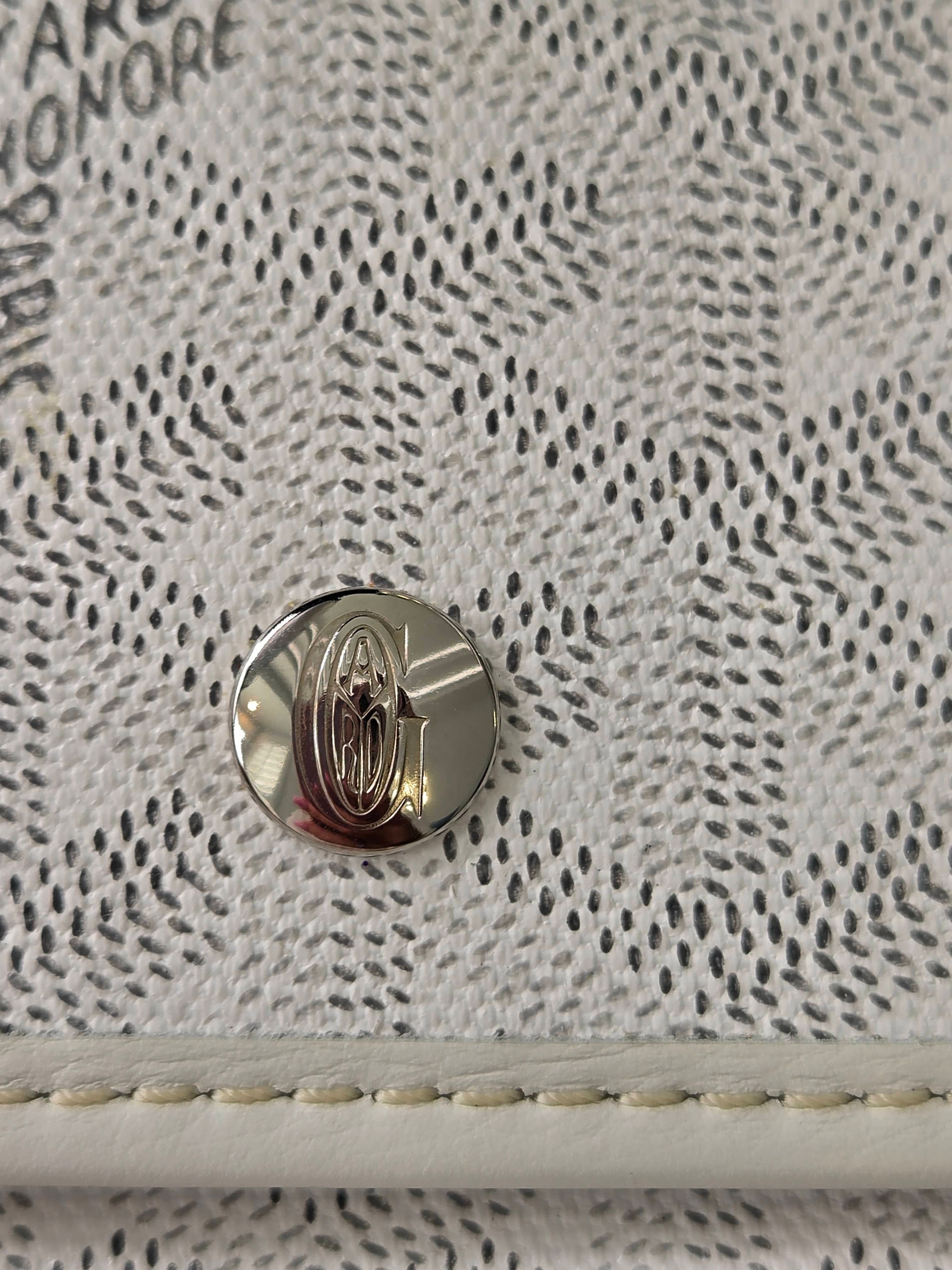 Close-up of a textured surface with a metallic emblem and visible stitching.