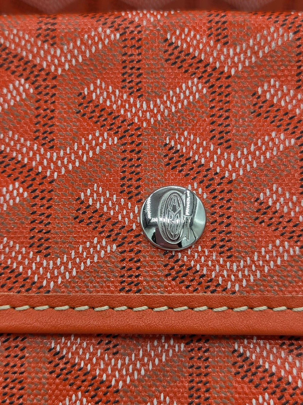 Close-up of a red textured fabric with a metal button in the center.
