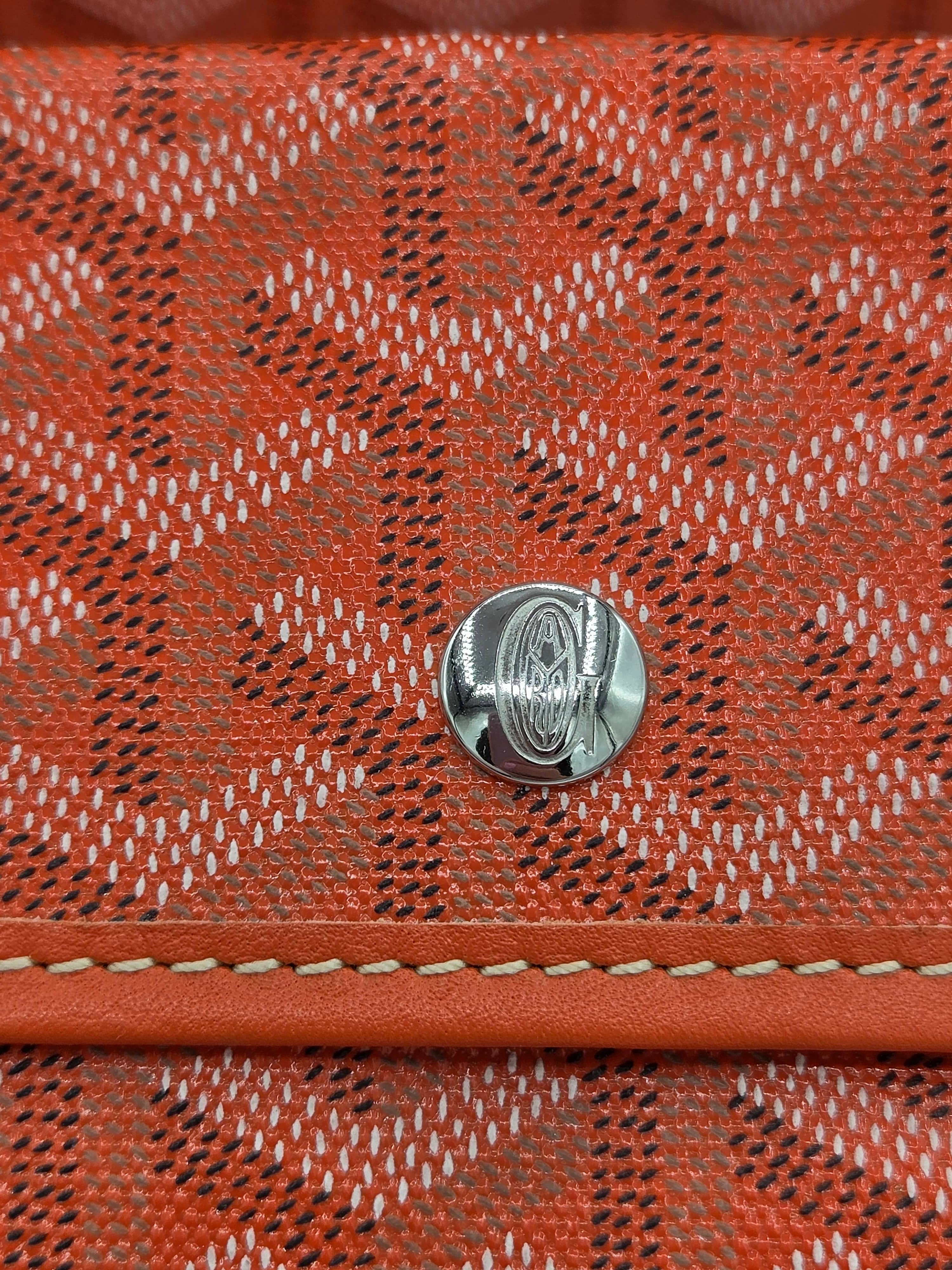 Close-up of a red textured fabric with a metal button in the center.