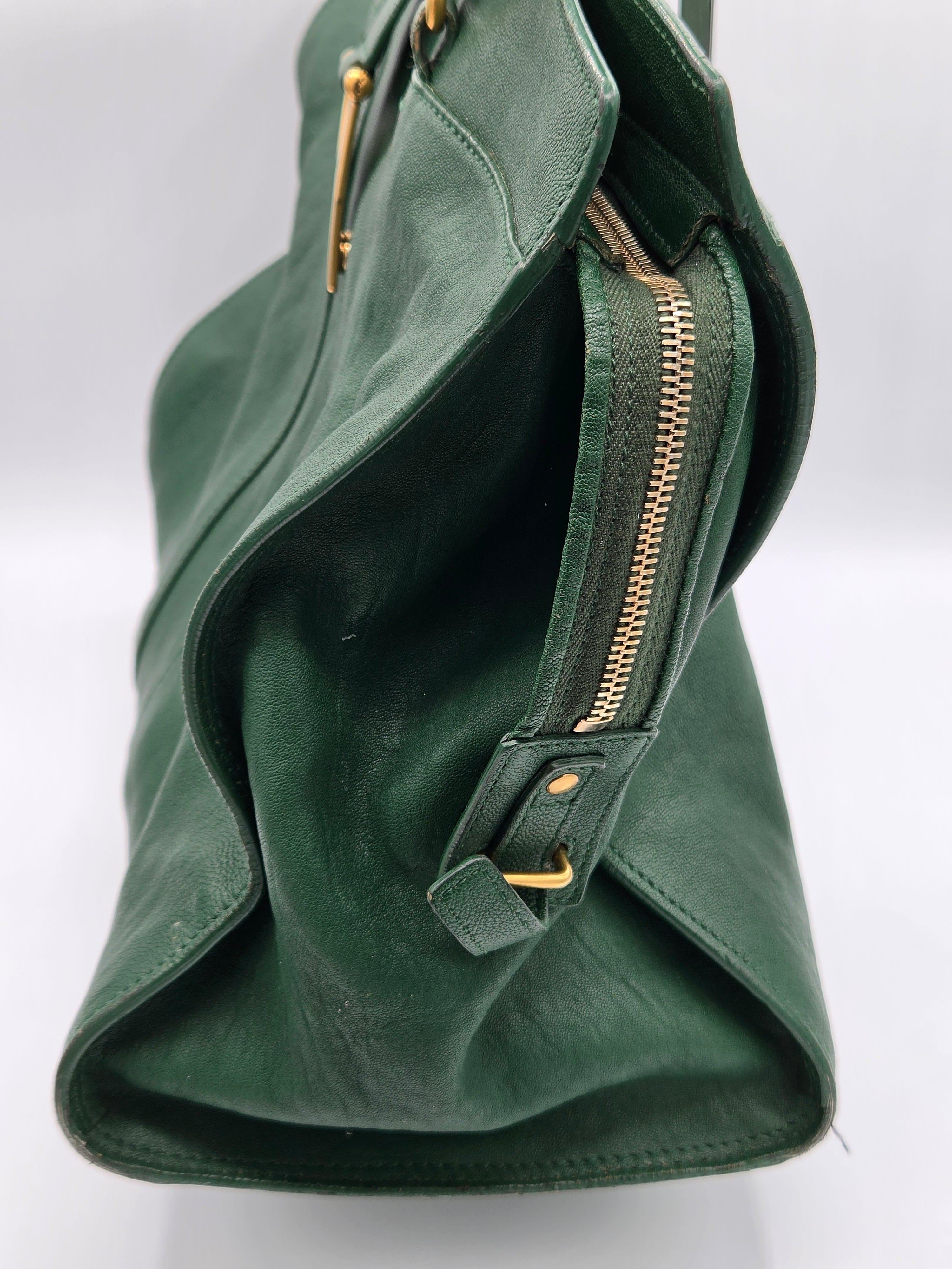 Green handbag with gold zippers on a white background