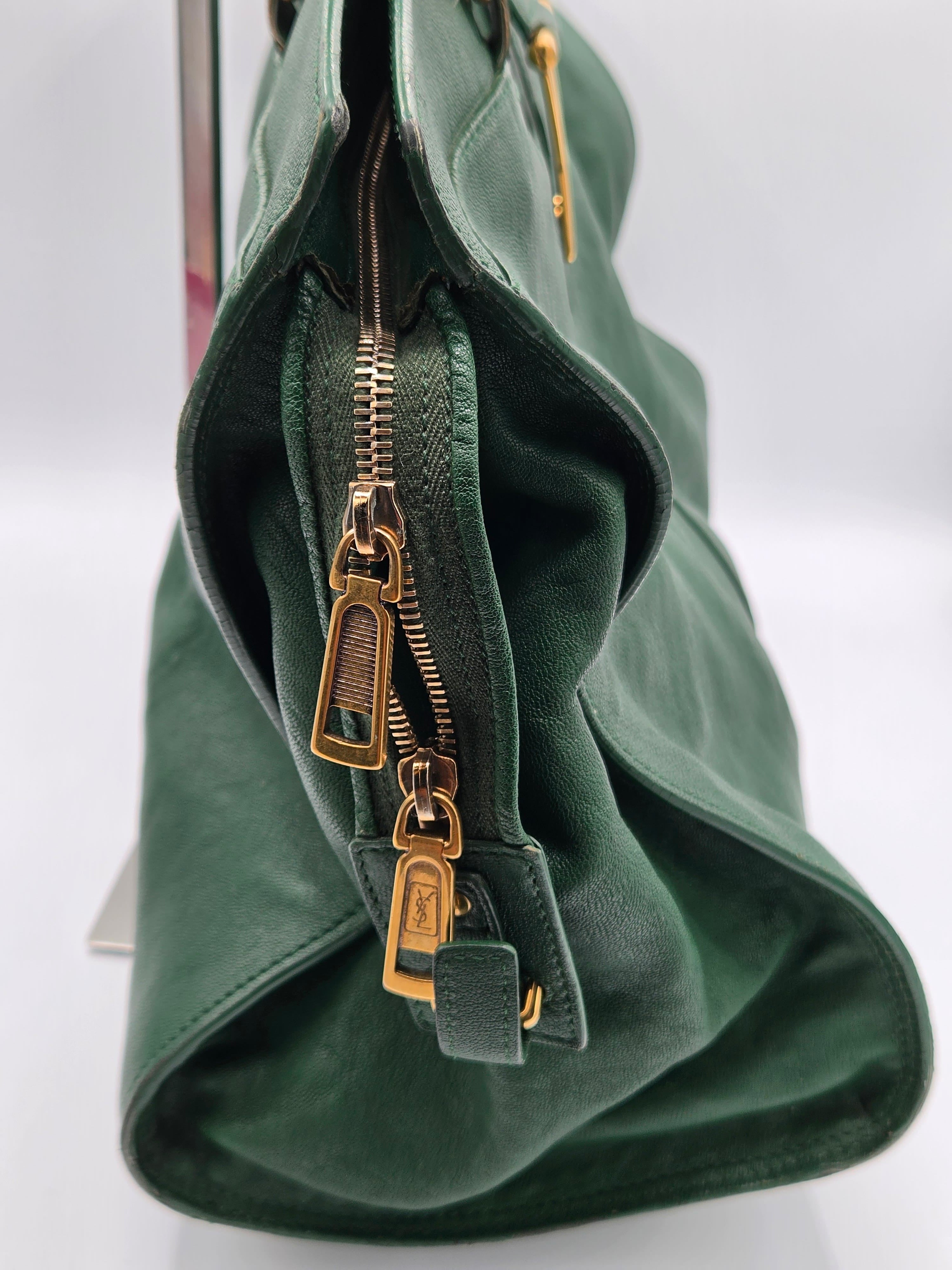 Green leather bag with gold zippers on a white background