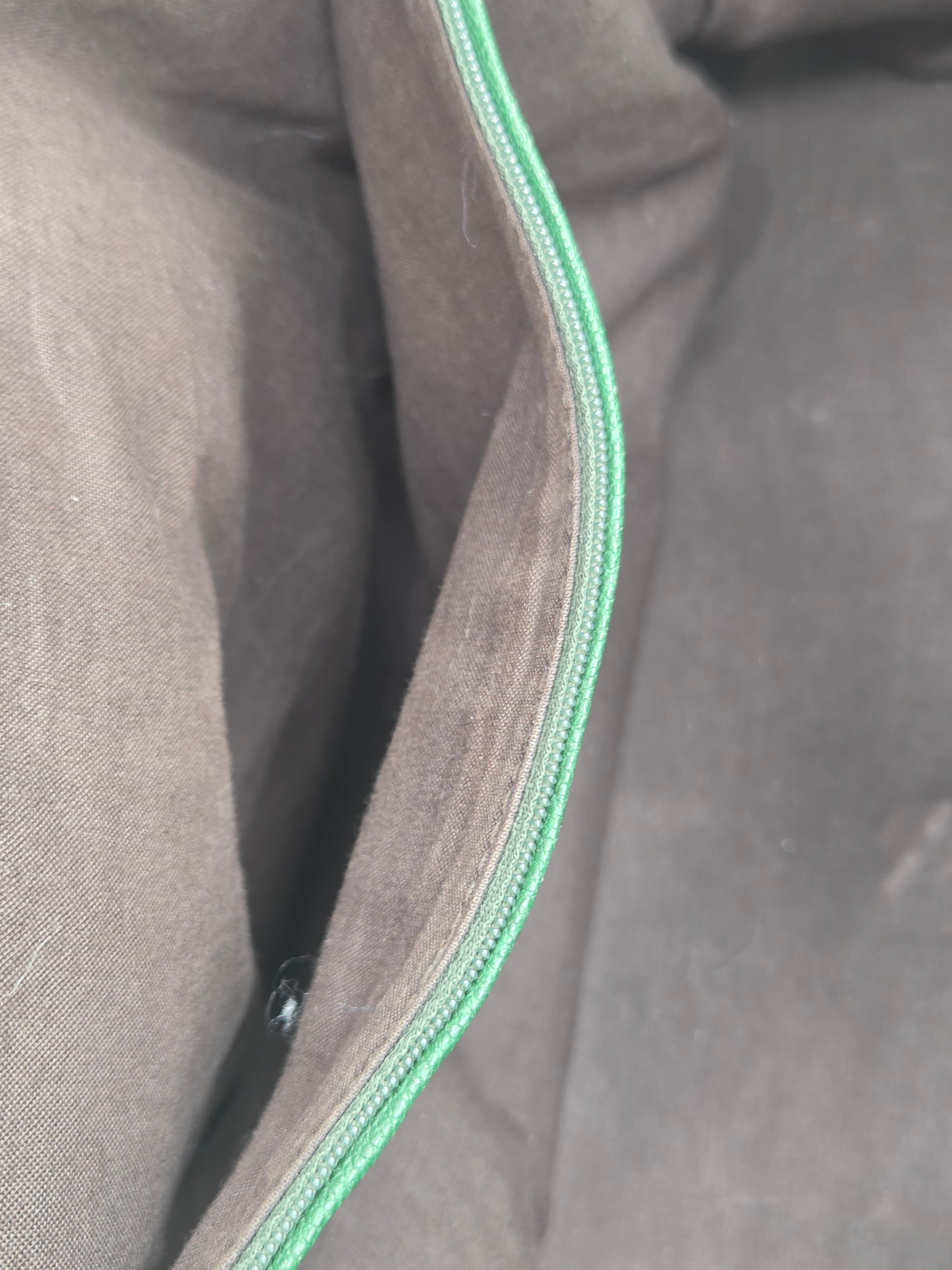 Close-up of gray fabric with a green zipper