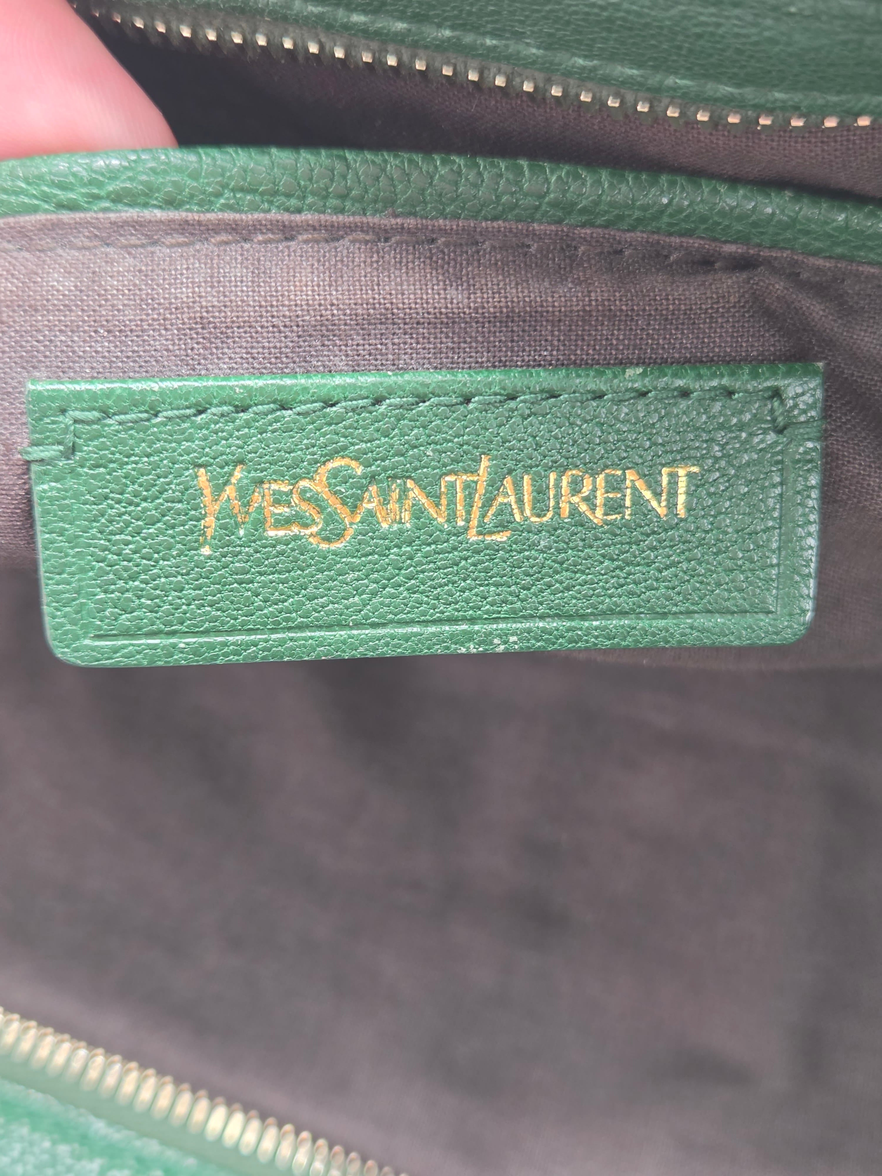 Green leather tag with 'Yves Saint Laurent' branding on a dark background