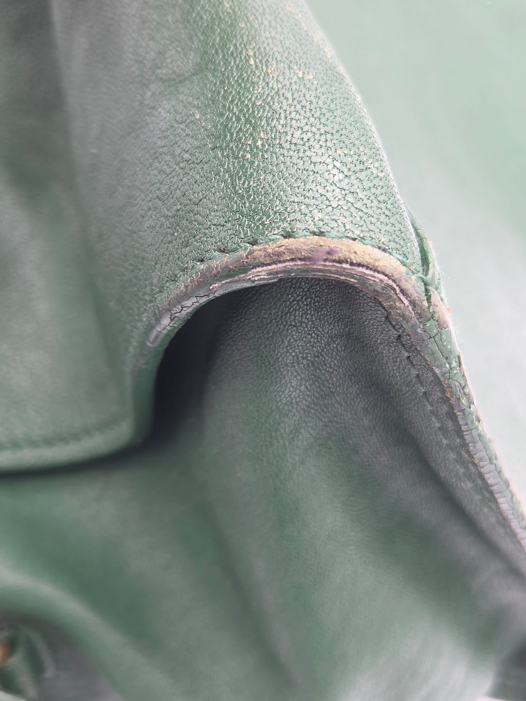 Close-up of a green leather surface with visible stitching