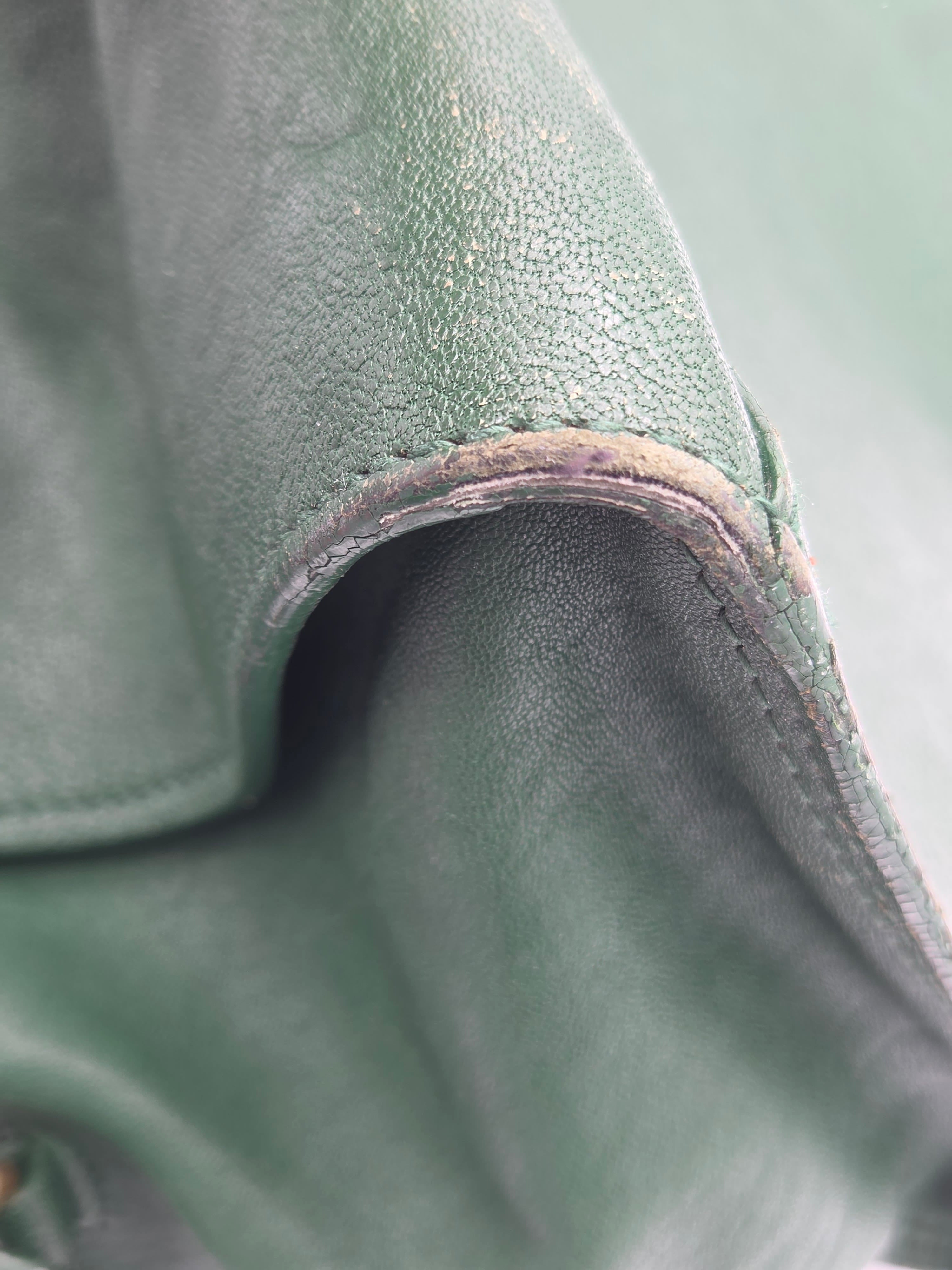 Close-up of a green leather surface with visible stitching