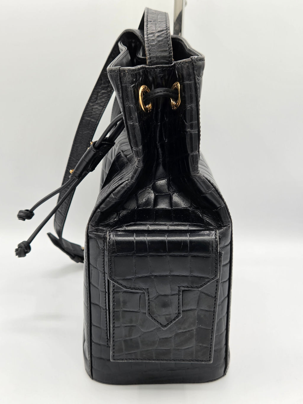 Black crocodile skin handbag with drawstring on a white background