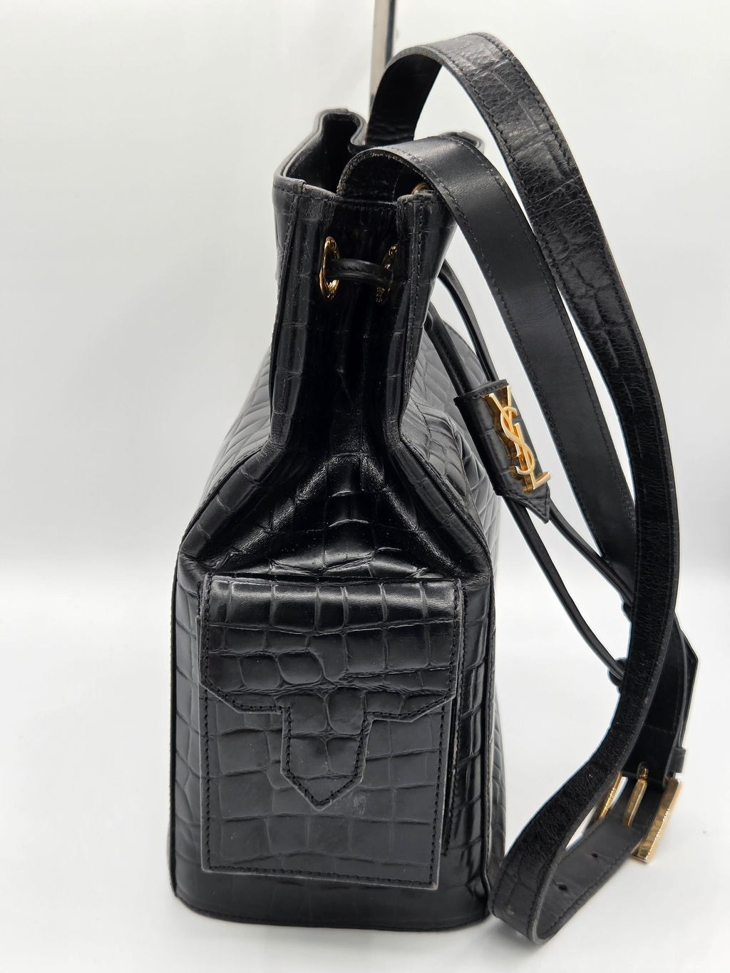 Black leather handbag with crocodile texture on a white background