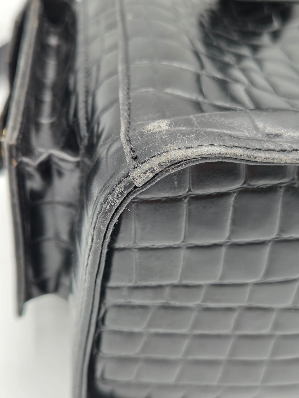Close-up of a quilted gray leather bag with a blurred background