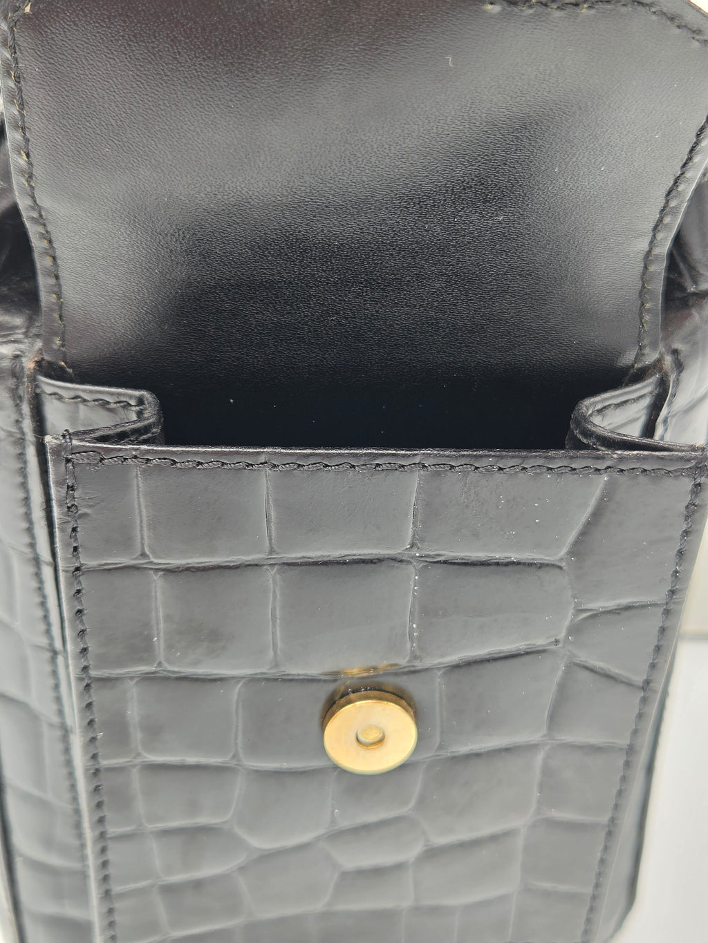 Close-up of a gray textured handbag with a gold button on a white background