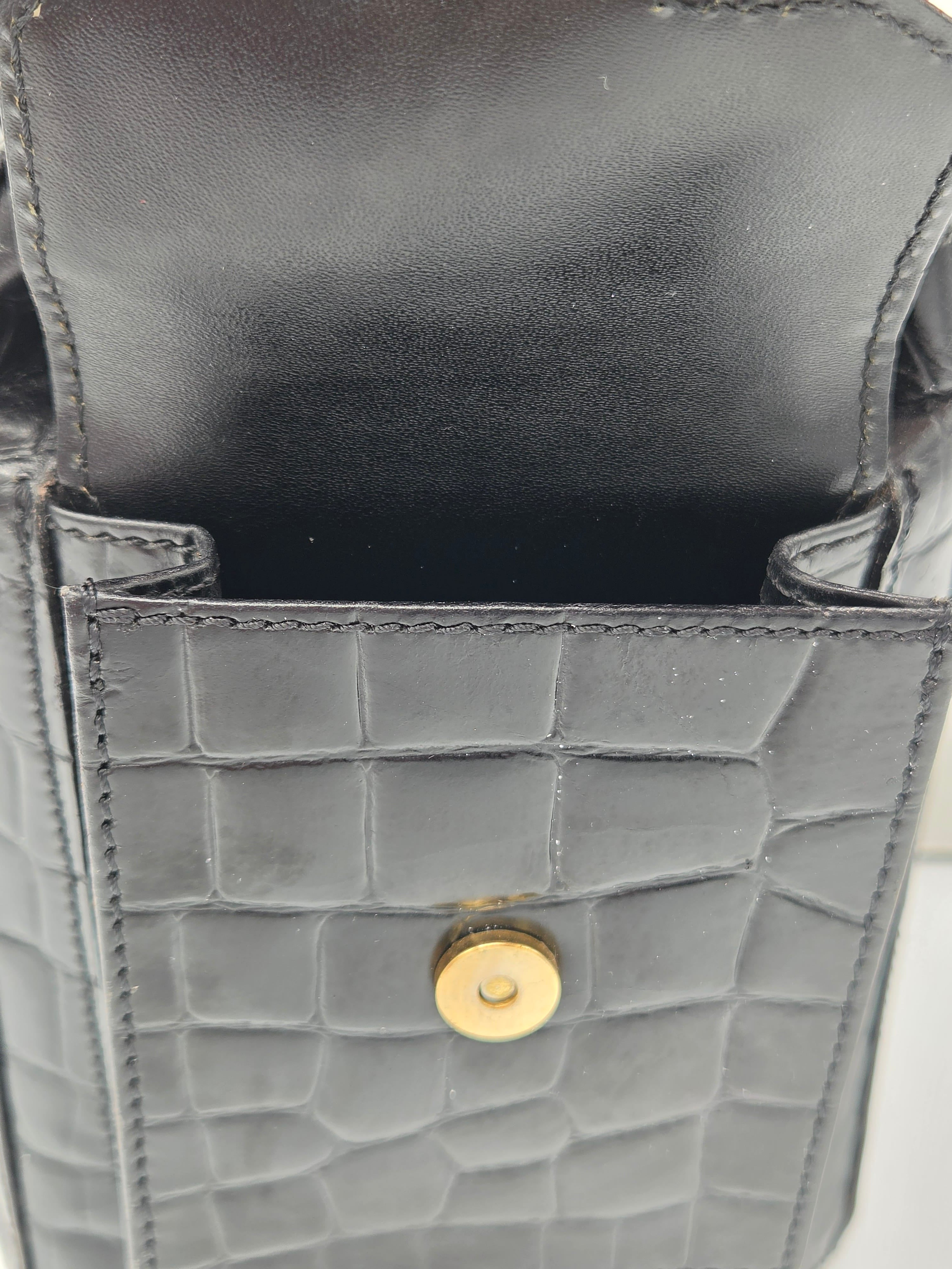 Close-up of a gray textured handbag with a gold button on a white background