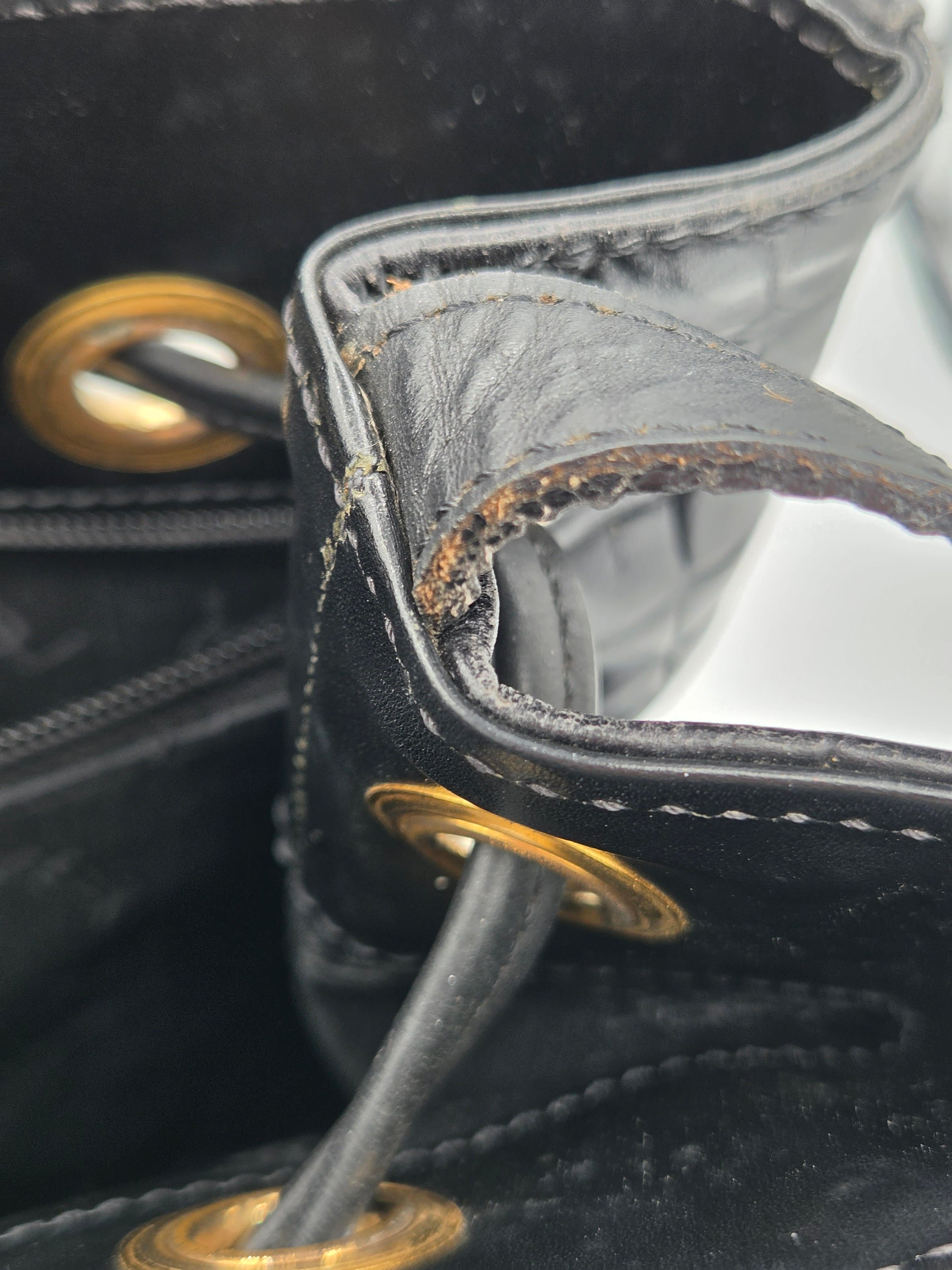 Close-up of a black leather handbag with gold hardware