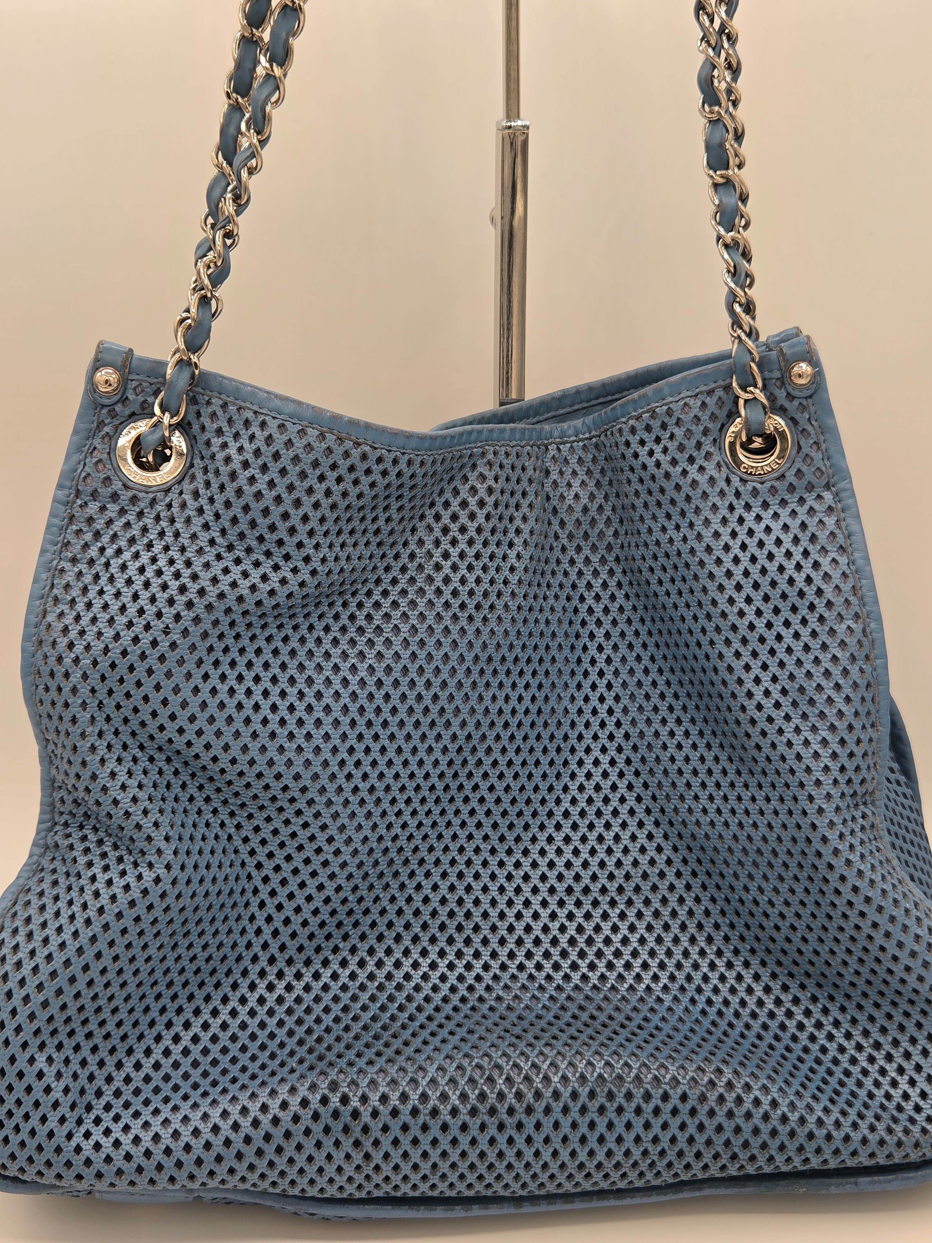 Blue handbag with chain strap on a beige background