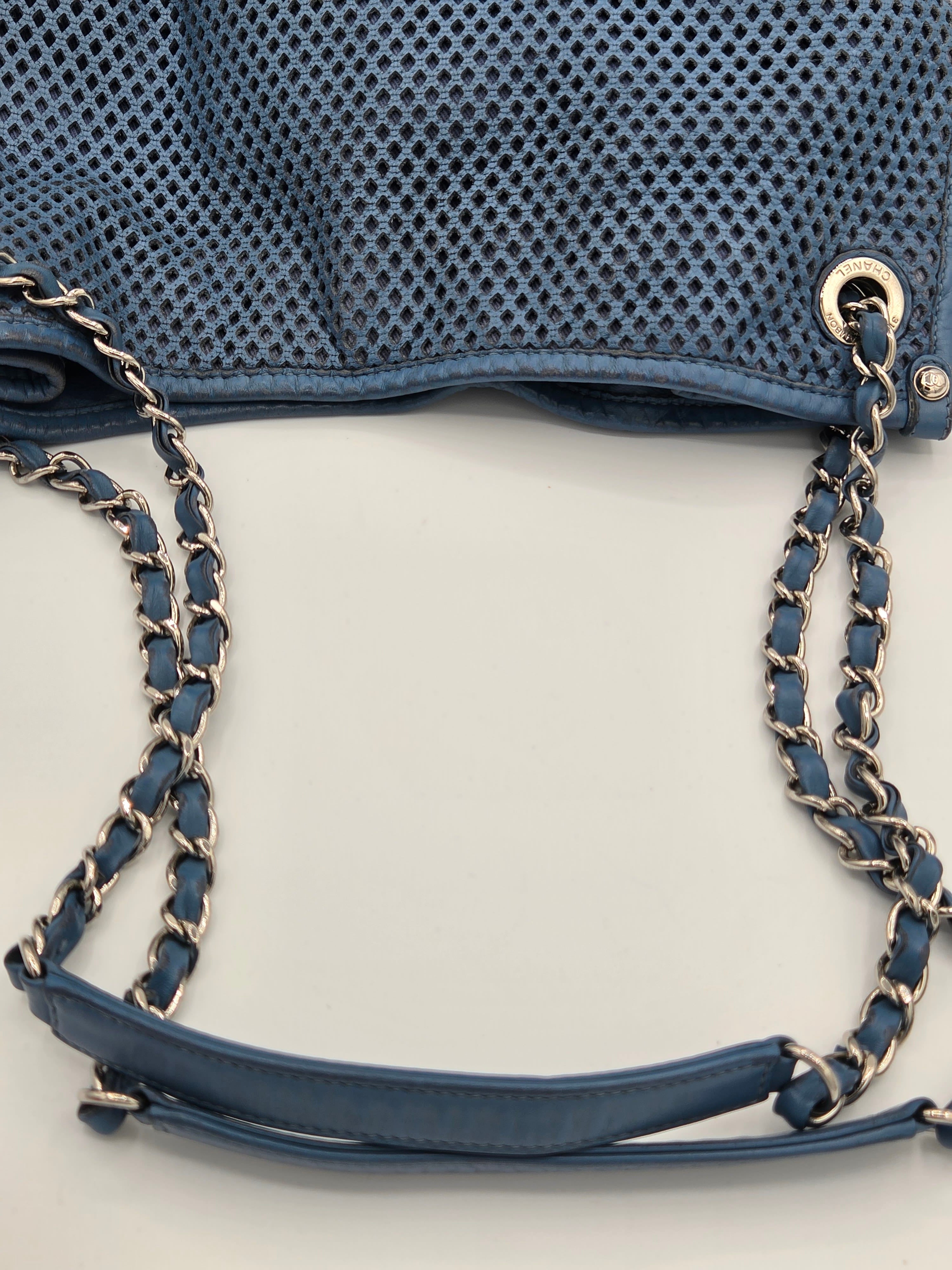 Blue handbag with chain strap on a light gray background