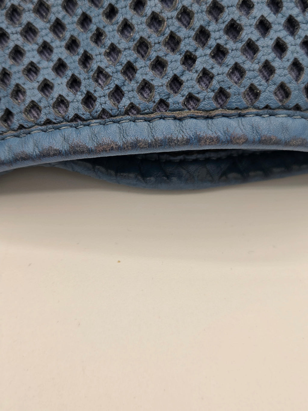 Close-up of a textured blue mat corner on a light beige surface