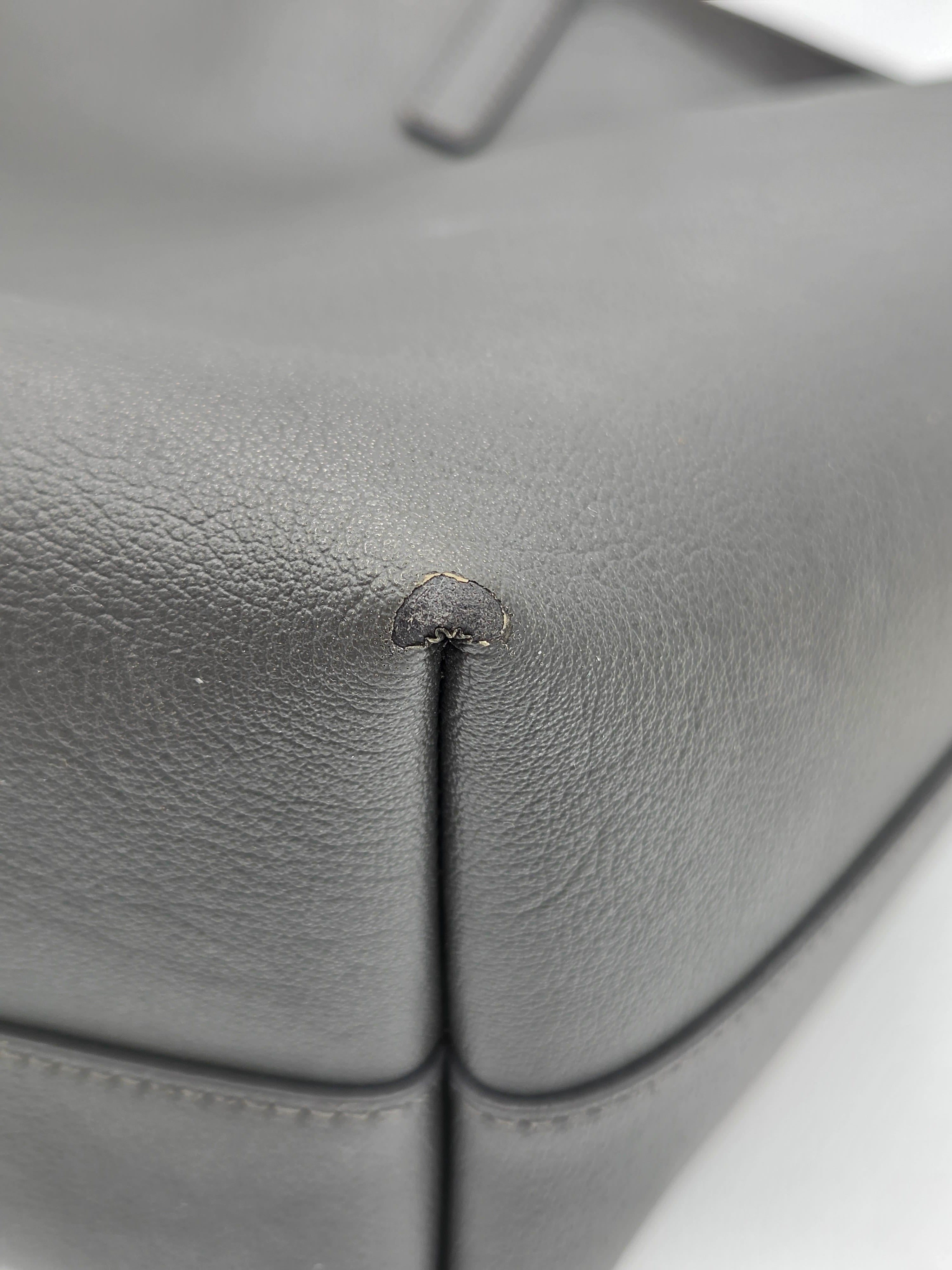Close-up of a gray leather car seat with a small scratch.
