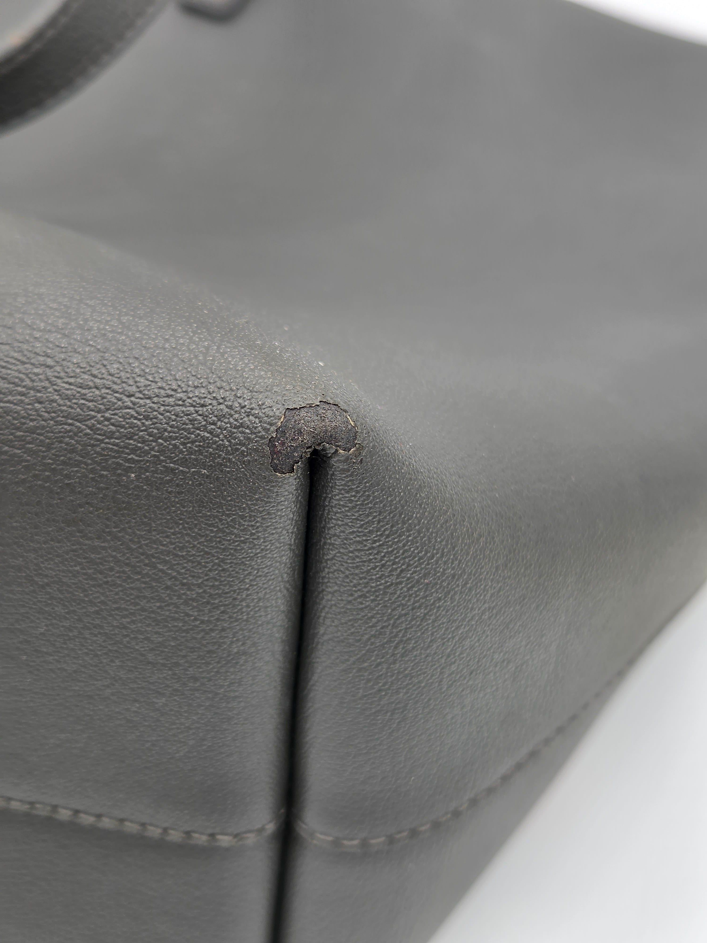 Gray leather car seat with a small tear or defect.