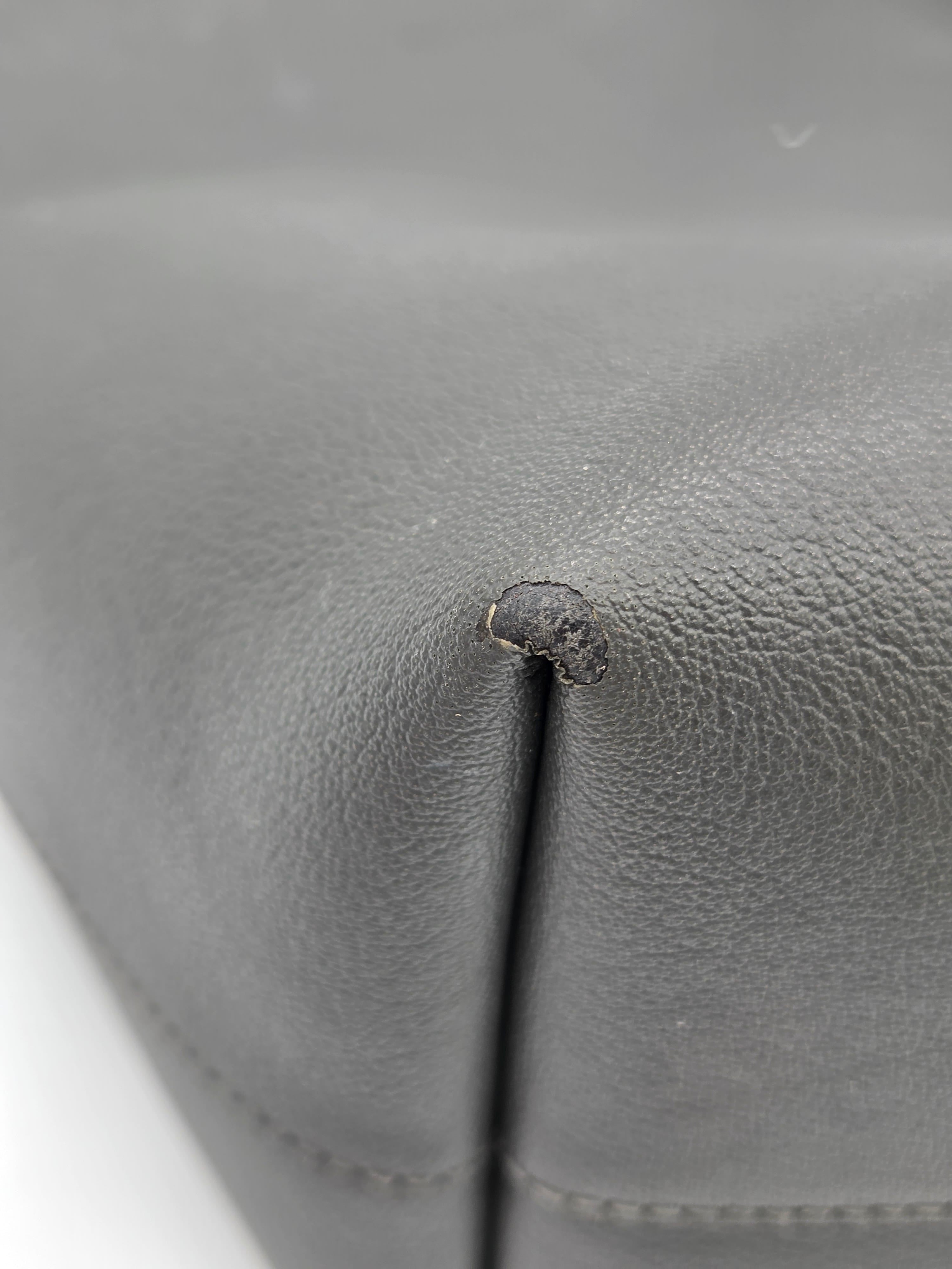 Close-up of a gray leather surface with a small dark spot.