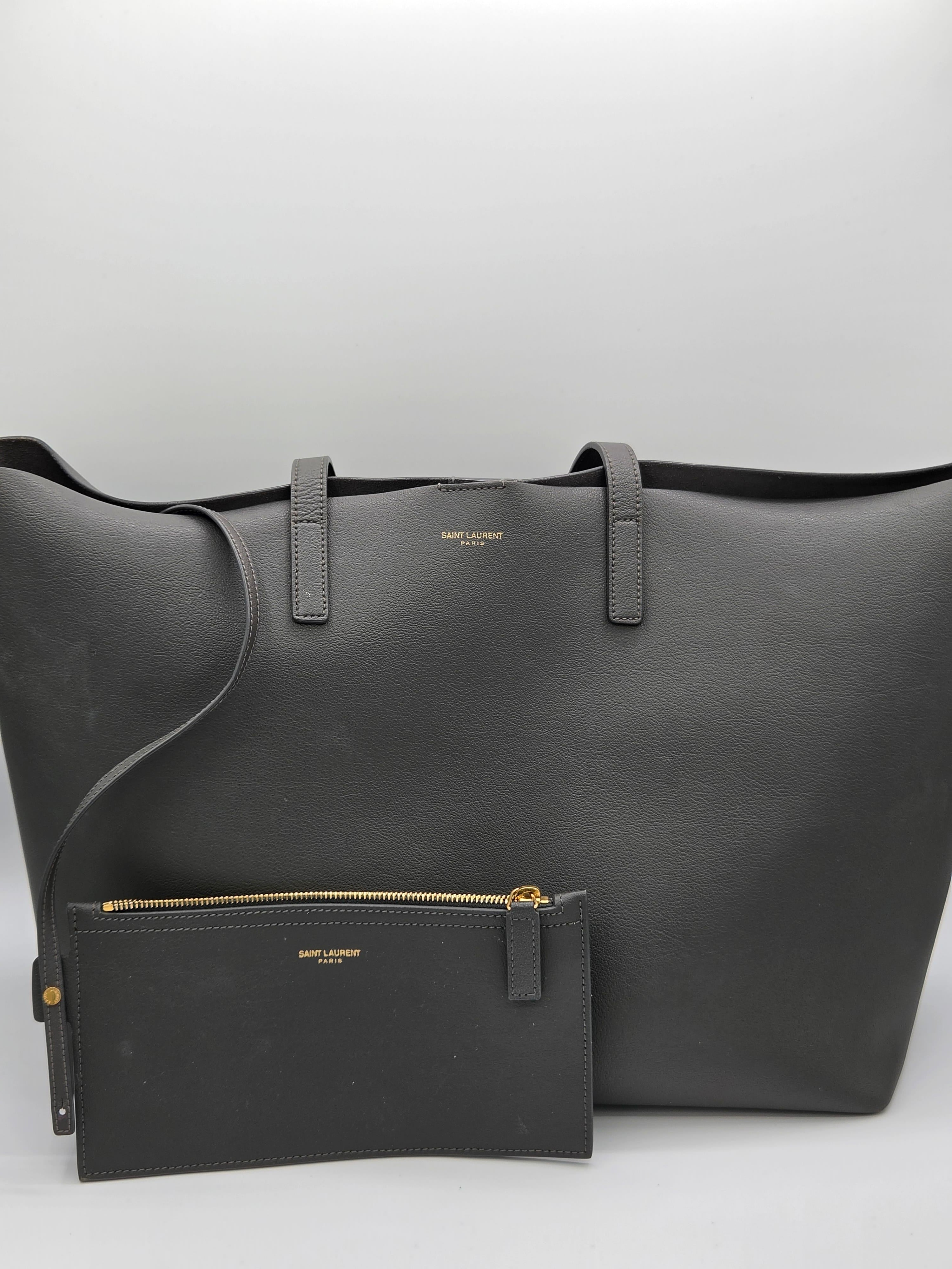 Black leather bag with a smaller pouch on a light gray background