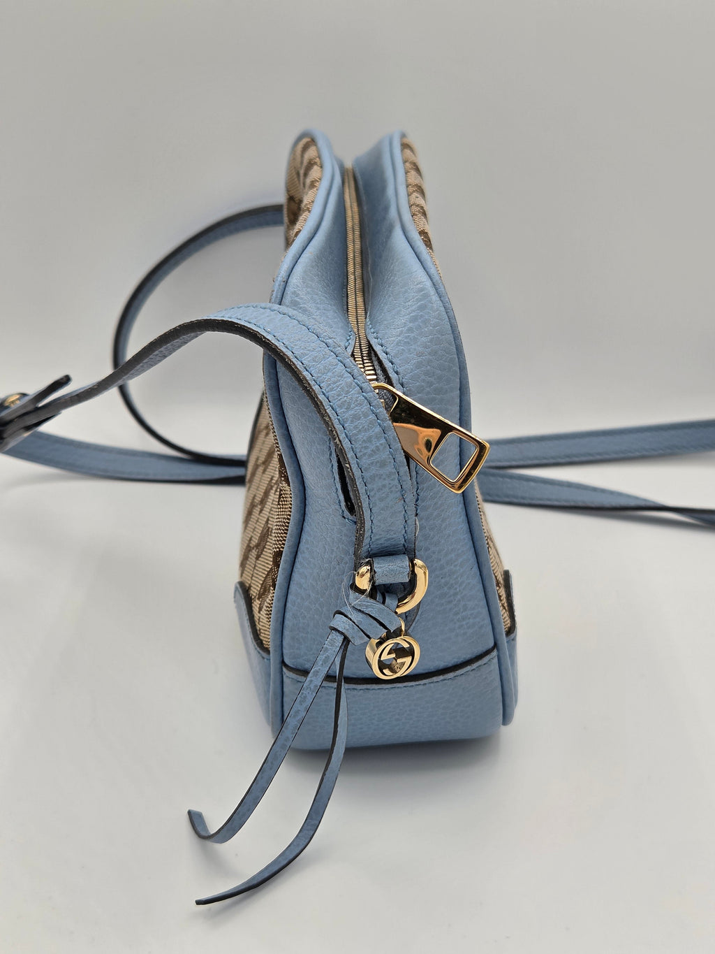 Blue handbag with gold accents on a light gray background